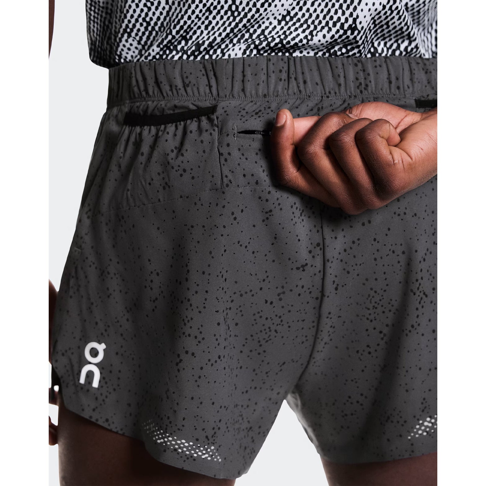 Men's On Zero Shorts Grey Black close-up of back storage showing one zip pocket and two mesh gel pockets
