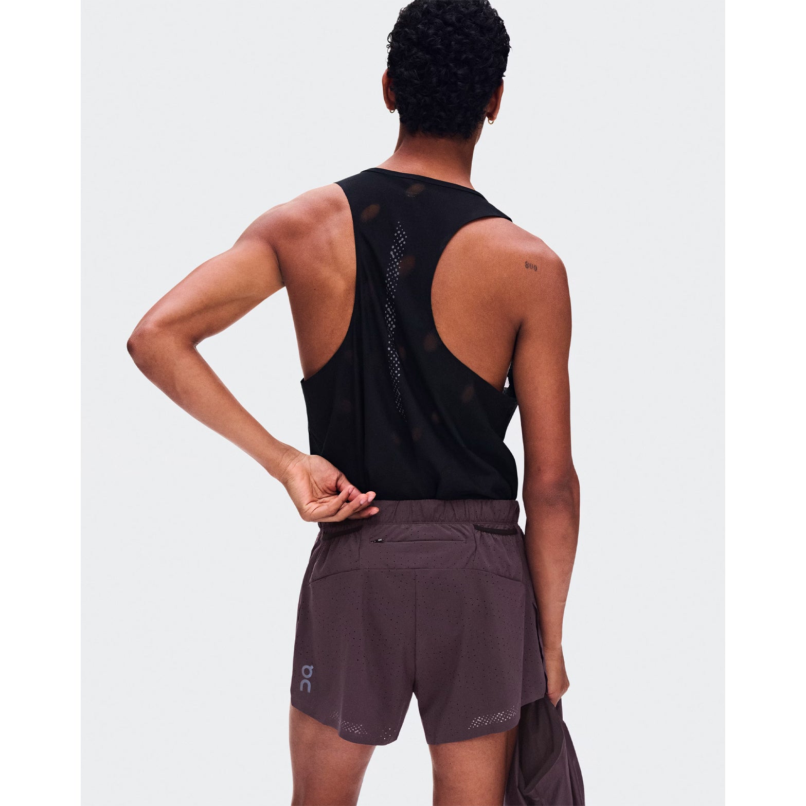 Men's On Zero Shorts Urchin back view on male runner showing zip pocket and two gel mesh pockets with perforated ventilation construction for race day storage and airflow