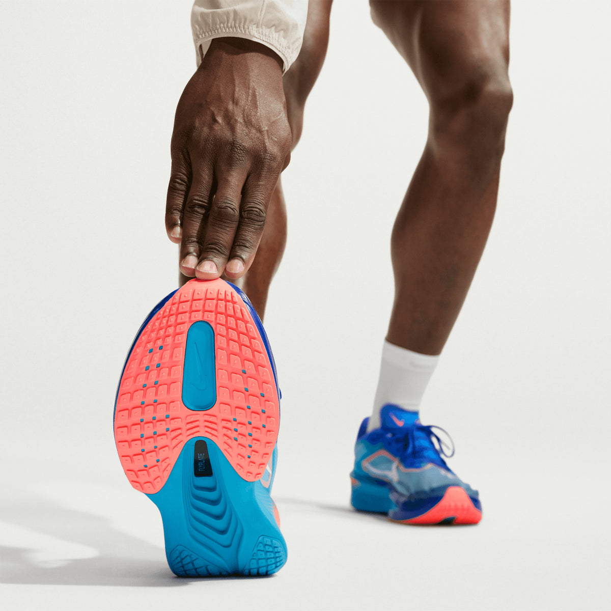 Men's Nike Zoom Fly 6 Running Shoes Racer Blue Blue Lightning Atomic Pink White sole view on male runner showing ReactX foam with full-length carbon fibre plate and durable outsole for tempo training and race day traction