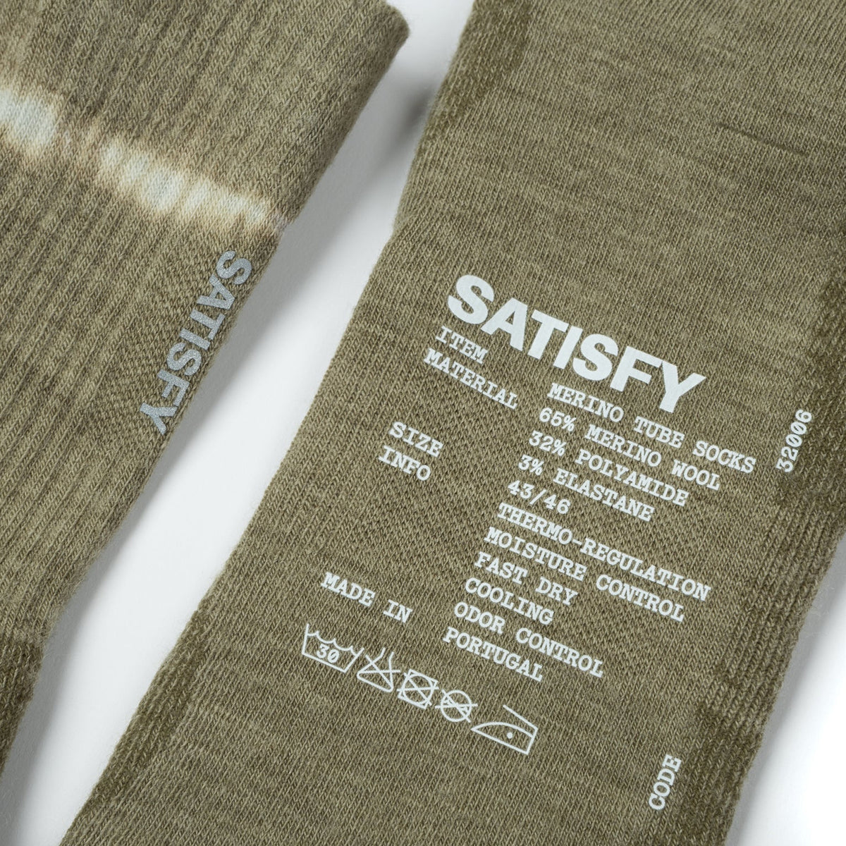 Satisfy Merino Nylon Tube Socks Covert Green close-up of hem showing rib-knit structure for secure non-restrictive fit with printed exterior care instructions