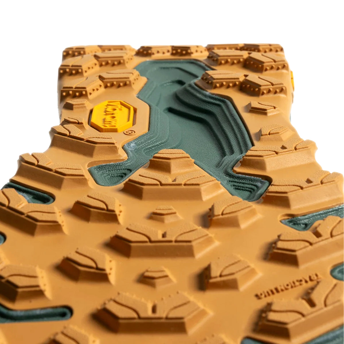 Close-up view of a rugged brown and green Vibram shoe sole, showing the textured, multi-directional lugs designed for traction and durability on uneven surfaces.