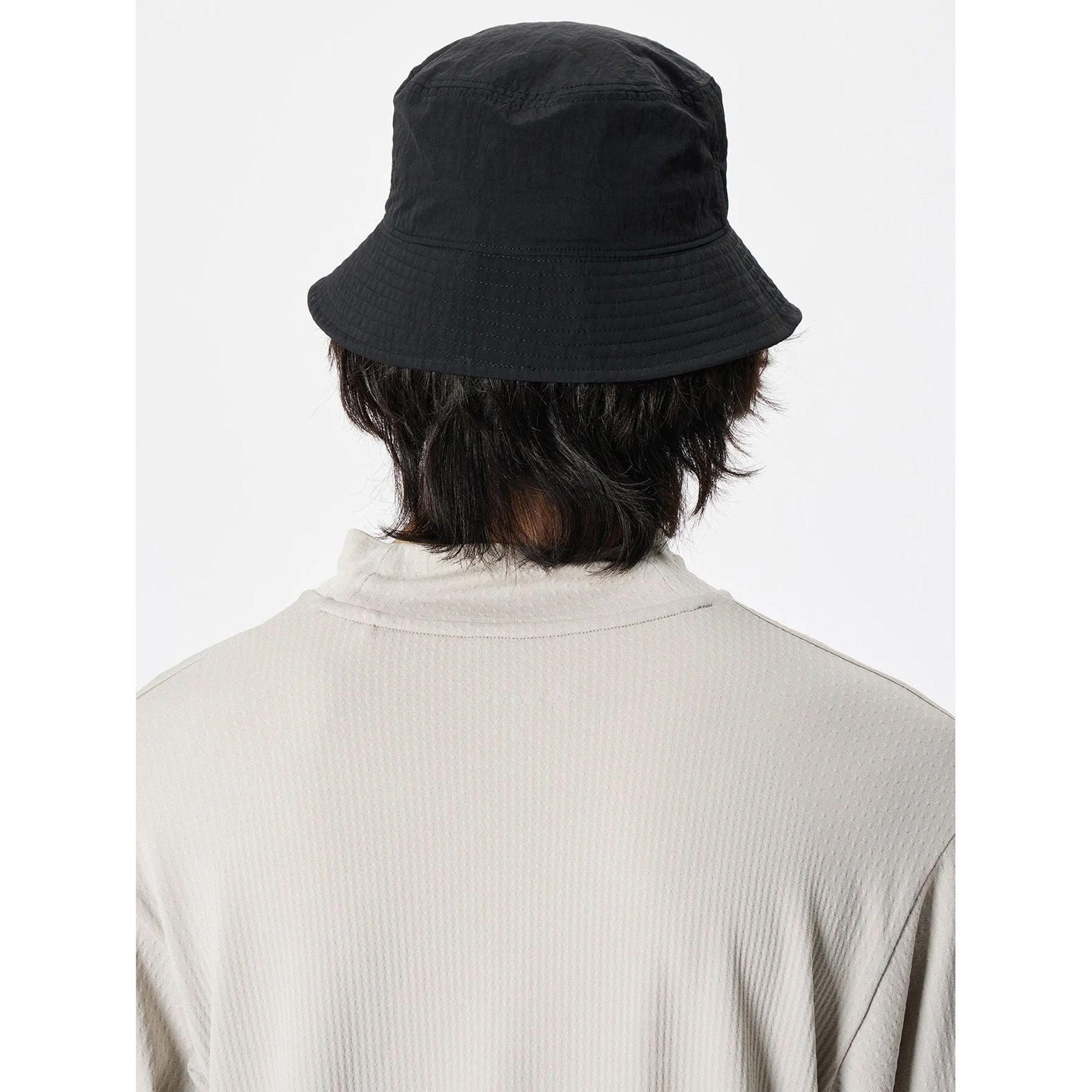 Goldwin Nylon Bucket Hat Black back view on male model showing back adjuster and recycled nylon construction with crisp finish