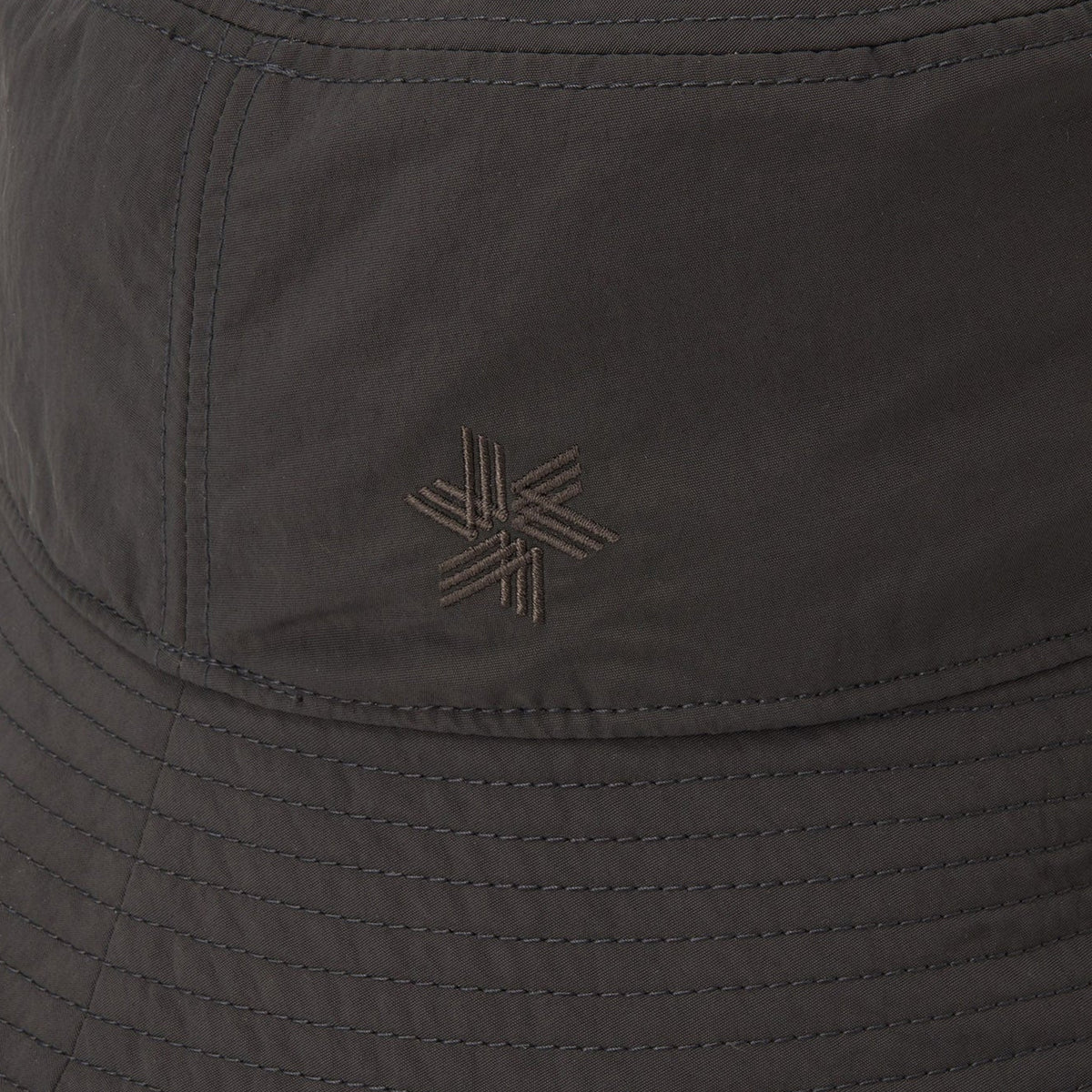 Goldwin Nylon Bucket Hat Black close-up of front logo showing densely woven recycled nylon with crisp smooth finish and water-repellent construction