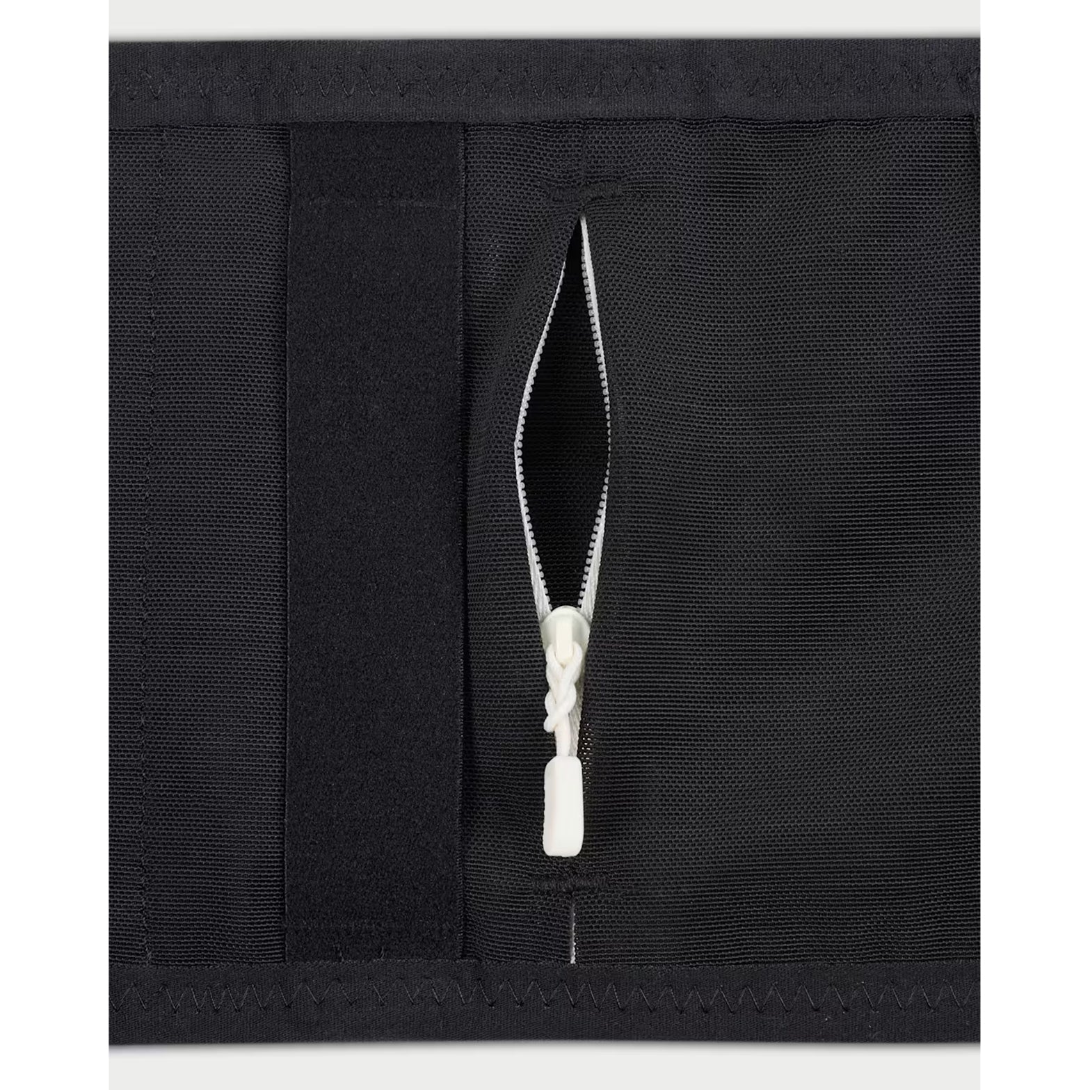 Nike Trail Running Belt in Black / Sail / Sail — closeup showing removable bungee system zip storage detail on black recycled polyester with sail accent piping