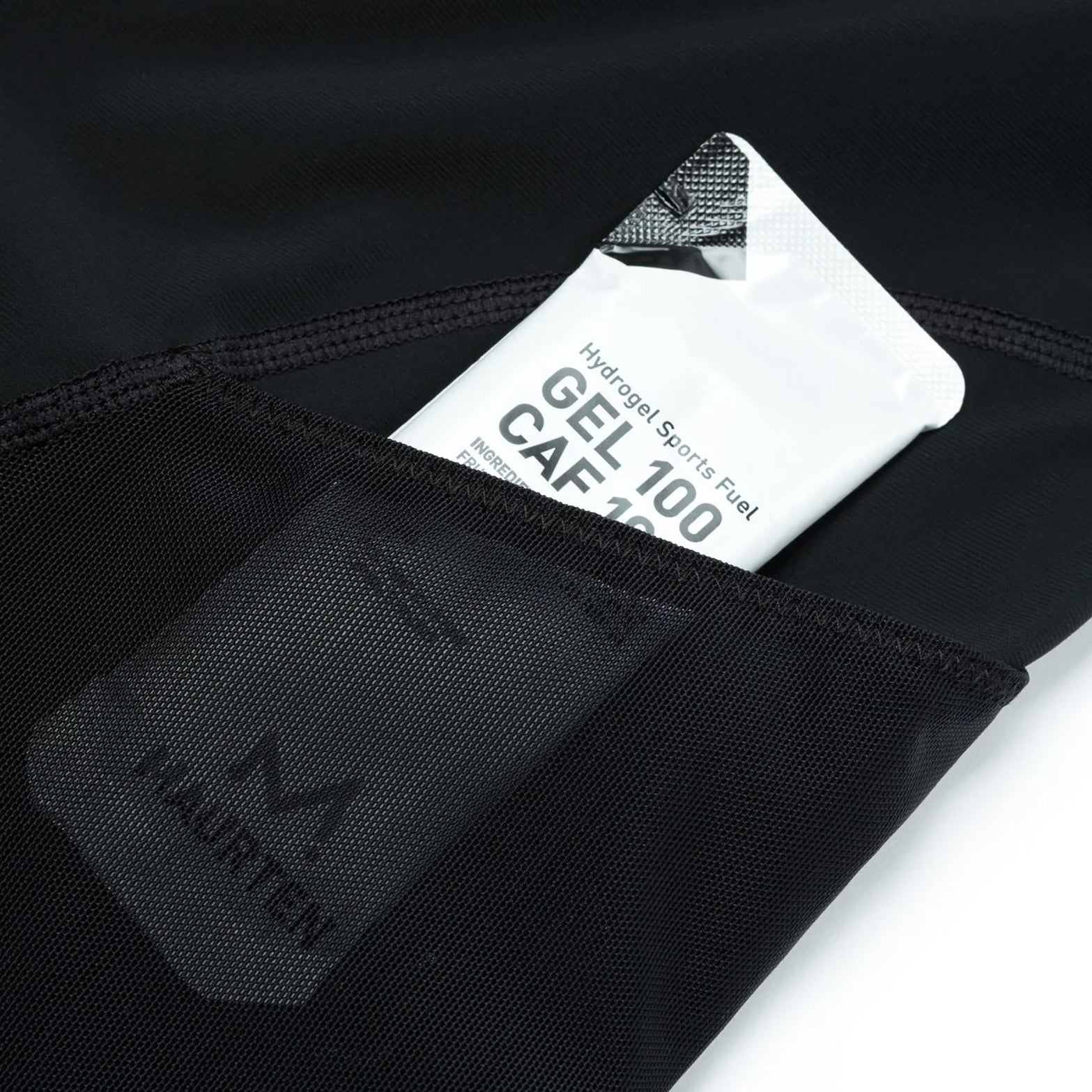 Satisfy TechSilk Evo 9 Inch Half Tights Black close-up showing gels stored in side cargo mesh pockets with secure fast-access design for nutrition without bounce during racing