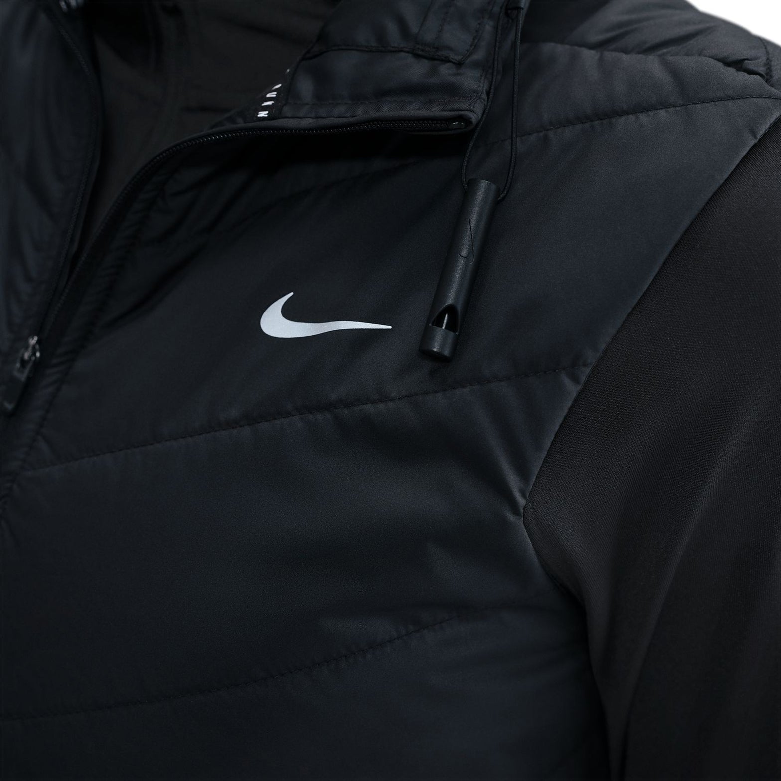 Nike Swift running vest collar closeup showing built-in safety whistle for cold-weather running