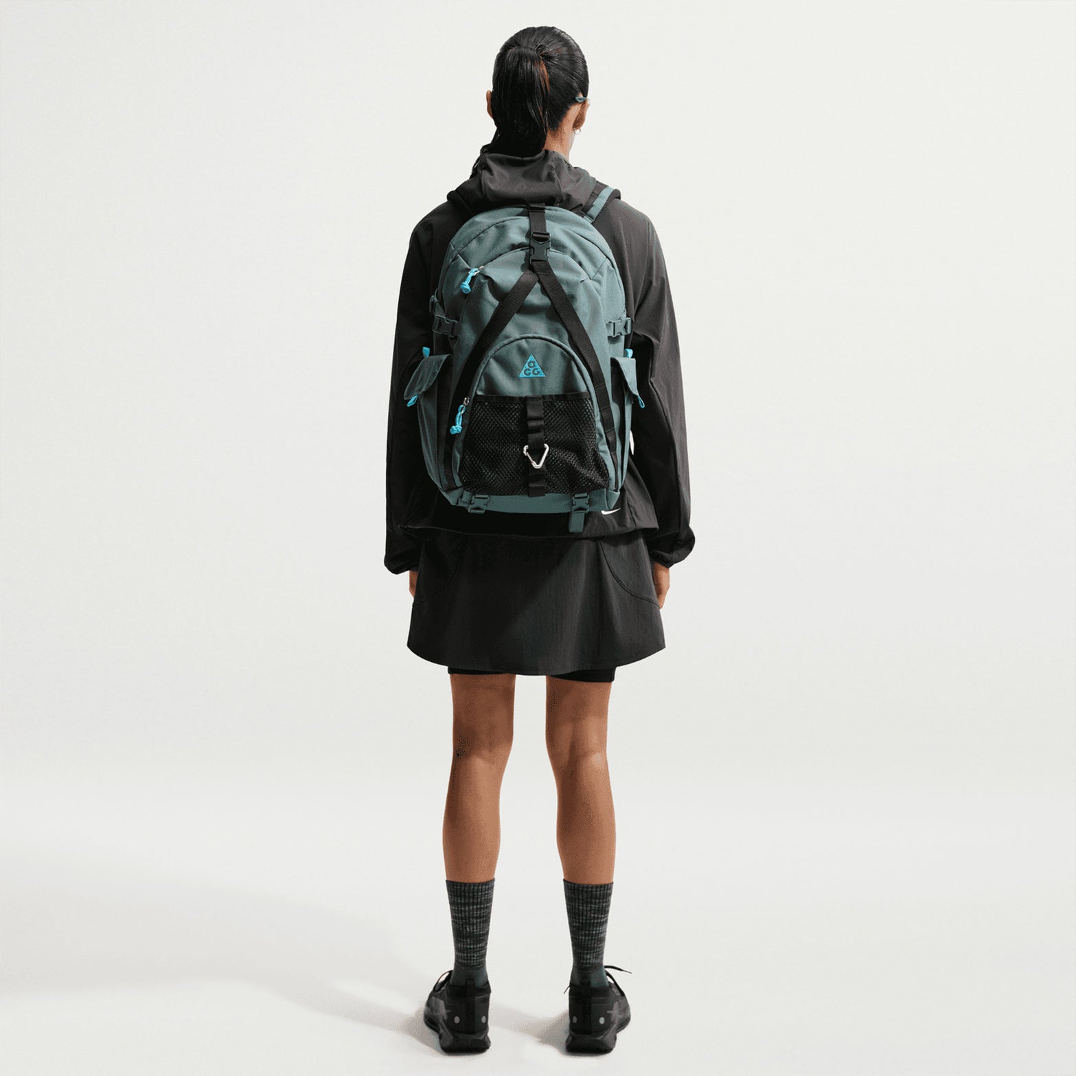 Women's Nike ACG Five Towers Skort Anthracite Summit White back full body view on female runner showing Dolomite mountain-inspired design with sweat-wicking technology and storage pockets