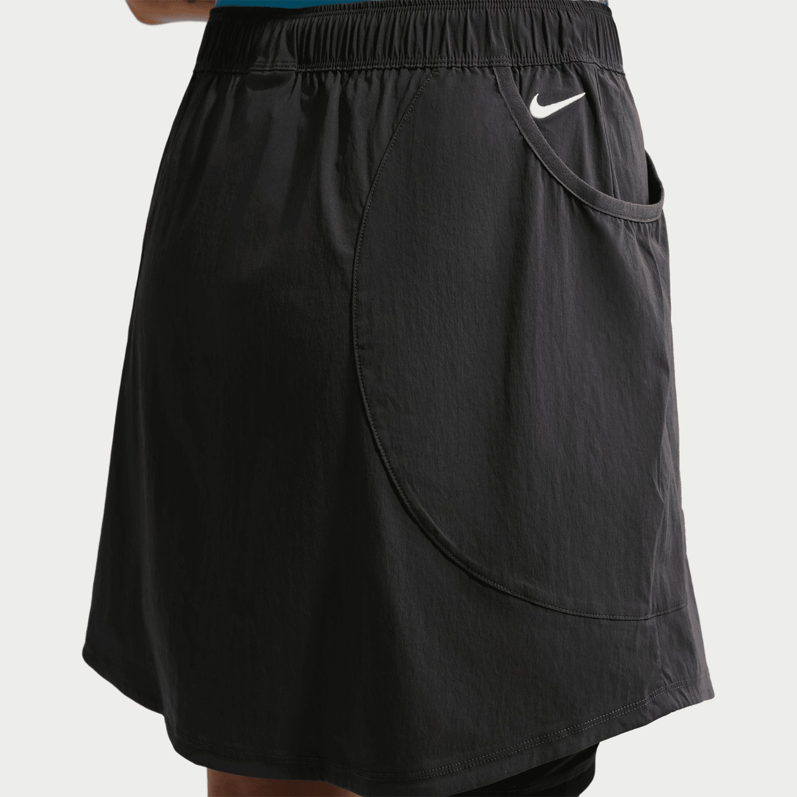 Women's Nike ACG Five Towers Skort Anthracite Summit White side view on female runner showing convertible design with side buttons, Dri-FIT moisture management and big drop-in pockets for trail running essentials