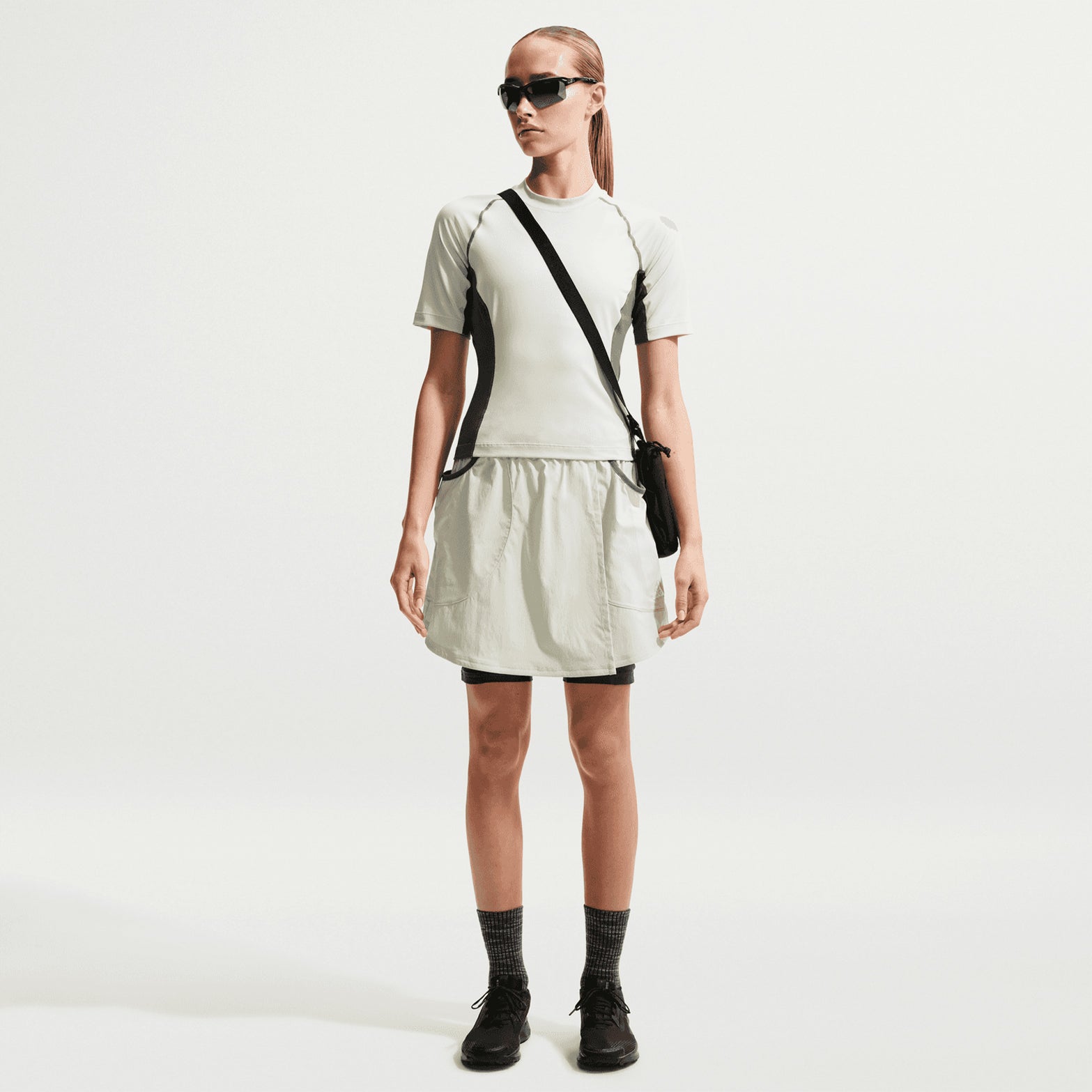 Women's Nike ACG Five Towers Skort Sea Glass Spruce Fog Summit White front full body view on female runner showing convertible skort design with buttons for switching between skirt, shorts or skort configuration