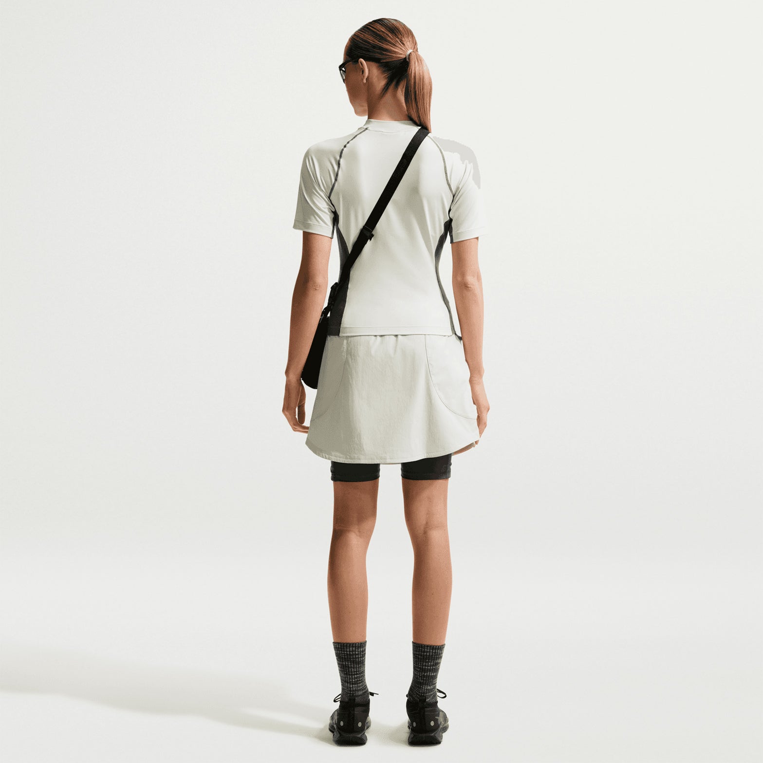 Women's Nike ACG Five Towers Skort Sea Glass Spruce Fog Summit White back full body view on female runner showing Dolomite mountain-inspired design with sweat-wicking technology and storage pockets
