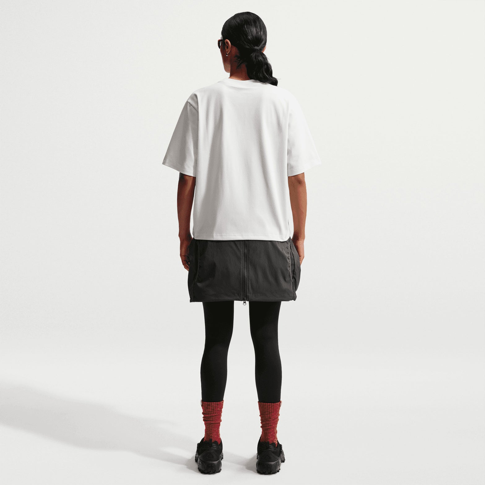 Nike ACG Tee women's in Summit White / Black — full body back view worn on model showing summit white loose-fit knit tee with black accent detailing and generous roomy cut for outdoor readiness