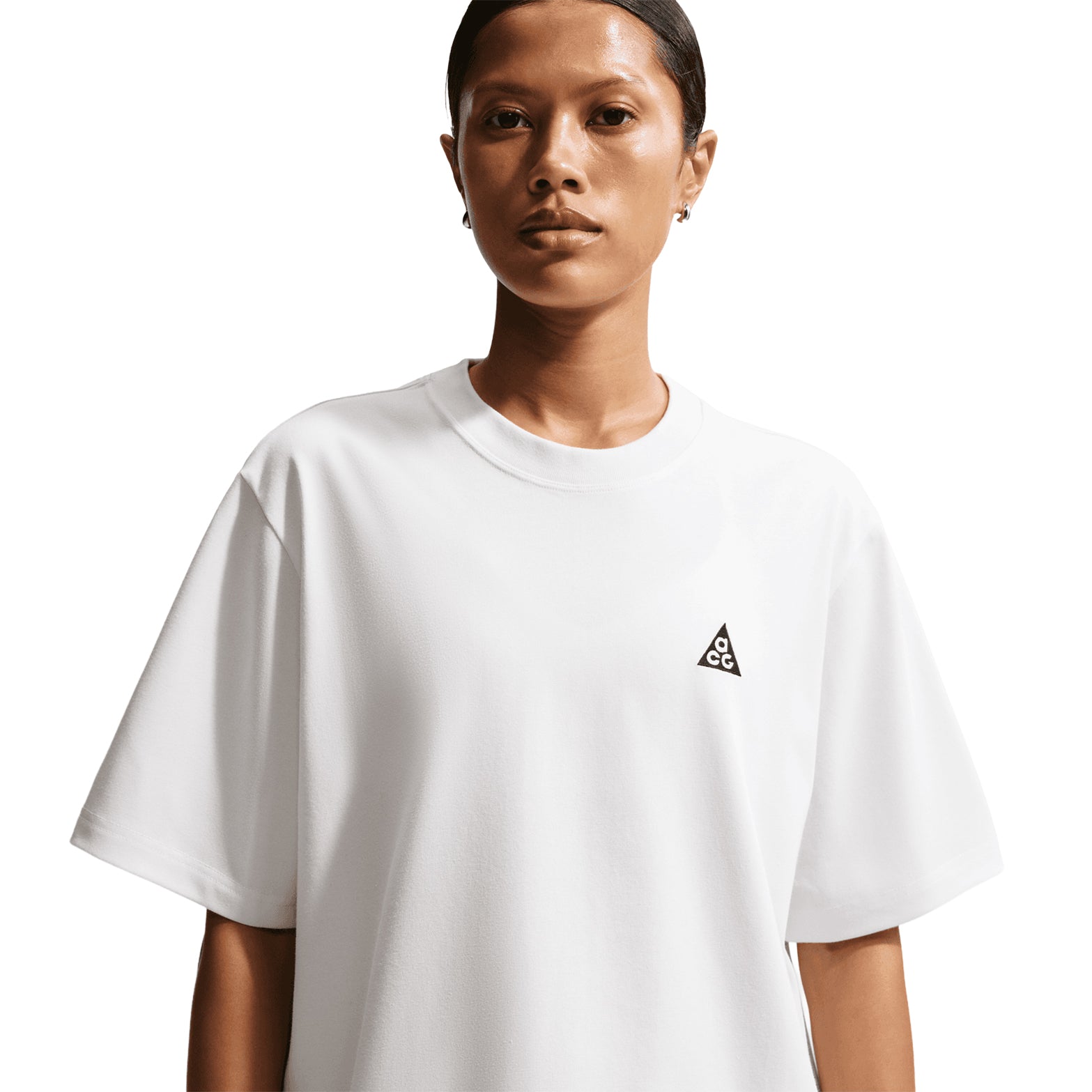 Nike ACG Tee women's in Summit White / Black — front view worn on model showing summit white loose-fit knit construction with black accent detailing and sweat-wicking technology