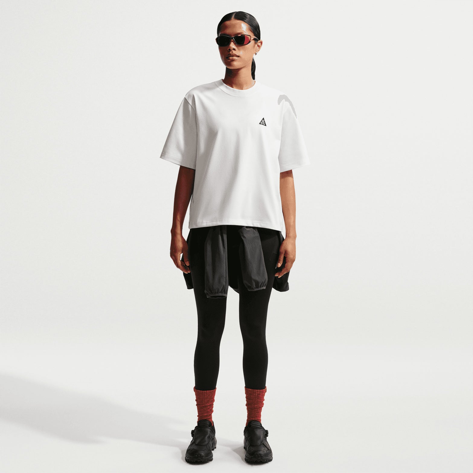 Nike ACG Tee women's in Summit White / Black — back view worn on model showing summit white loose-fit knit construction with black accent detailing and relaxed roomy fit