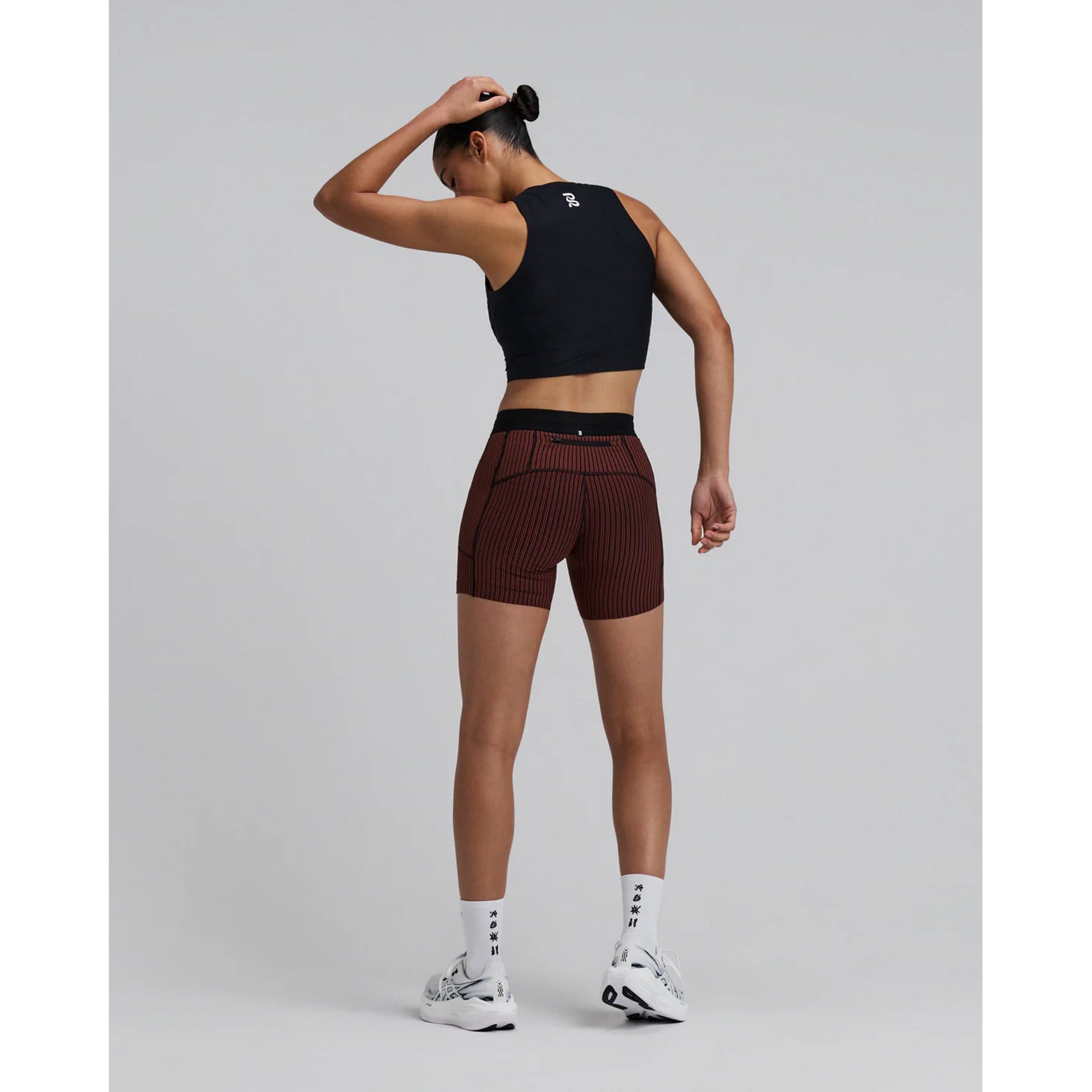 Women's Bandit Adapto Distance Race Top Black full body back view on female runner showing Acrofuse bonded seams that lay flat against skin with reflective branding