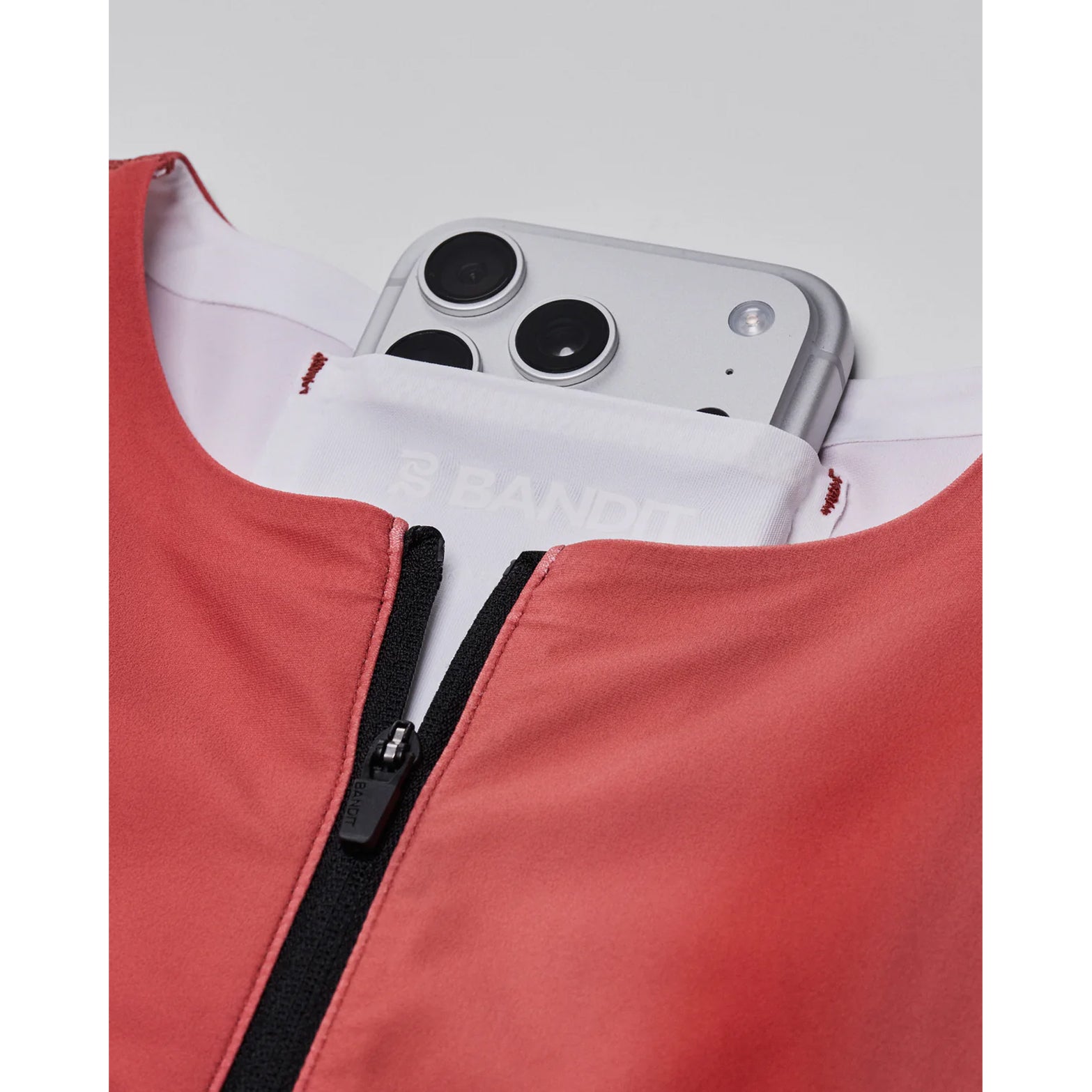 Bandit Adapto Distance Race Top women's in Salt Stain Rusted Apricot — closeup showing internal phone pocket at back neck integrated into the Acrofuse™ bonded construction