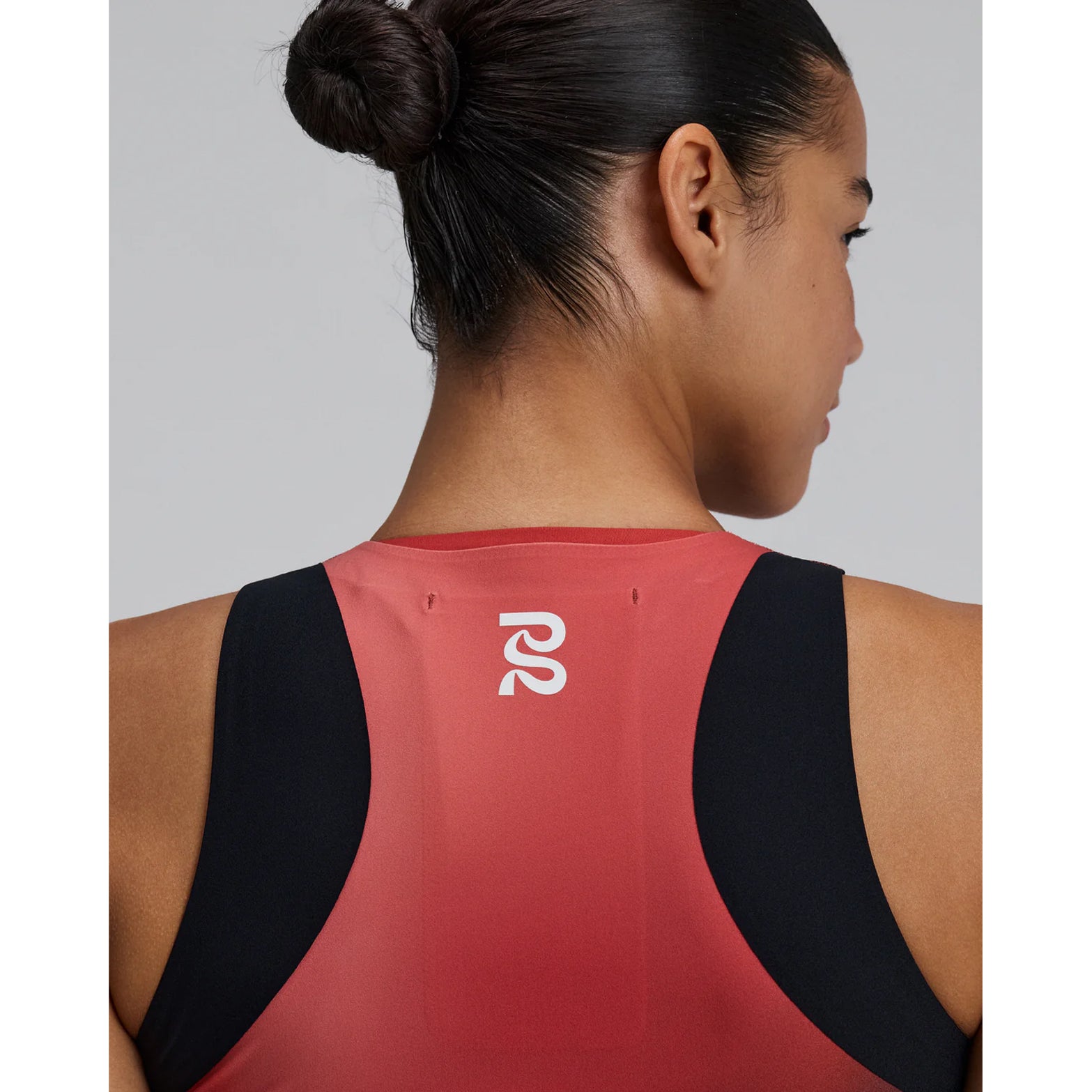 Bandit Adapto Distance Race Top women's in Salt Stain Rusted Apricot — closeup showing Acrofuse™ bonded seam construction, reflective Bandit branding and salt stain rusted apricot Adapto™ compression fabric detail at back