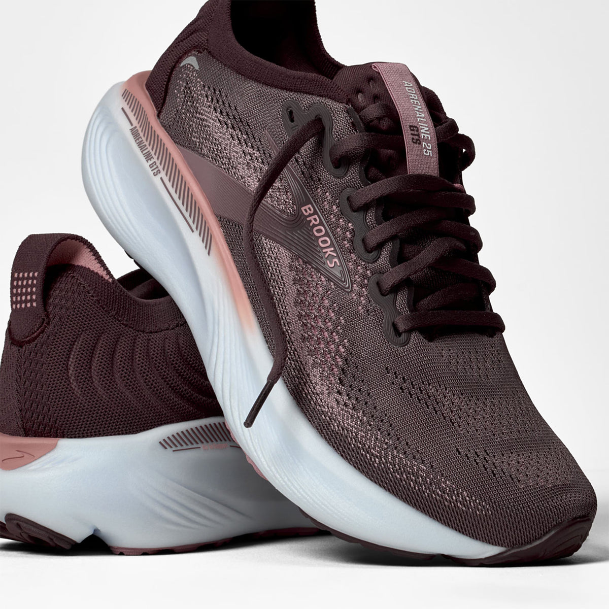 Brooks Adrenaline GTS 25 women's running shoe in Raisin / Woodrose / White — angled side view showing raisin engineered mesh upper, GuideRails support sidewalls and woodrose DNA LOFT cushioning midsole stack