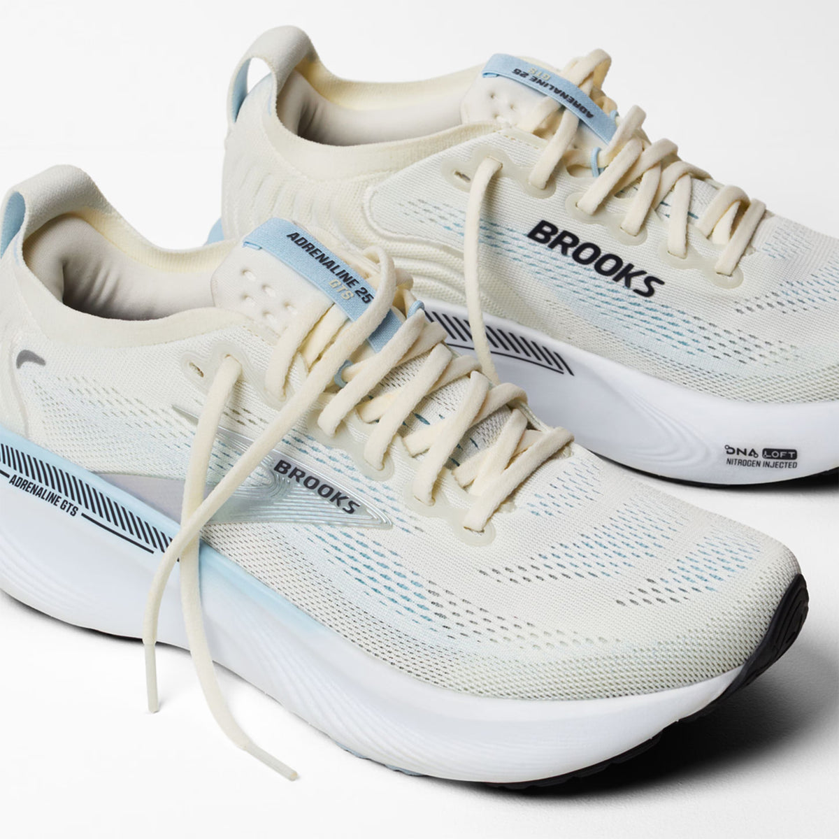 Brooks Adrenaline GTS 25 women's running shoe in Star White / Nantucket / Chrome — angled side view showing star white engineered mesh upper, GuideRails support sidewalls and nantucket DNA LOFT cushioning midsole stack