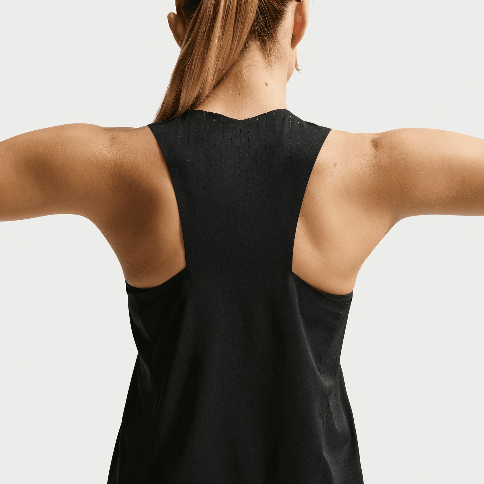Nike AeroSwift Dri-FIT ADV Women's Running Vest in Black / White — back view worn on model showing pleated back detail, side slit airflow construction and black Dri-FIT ADV fabric 
