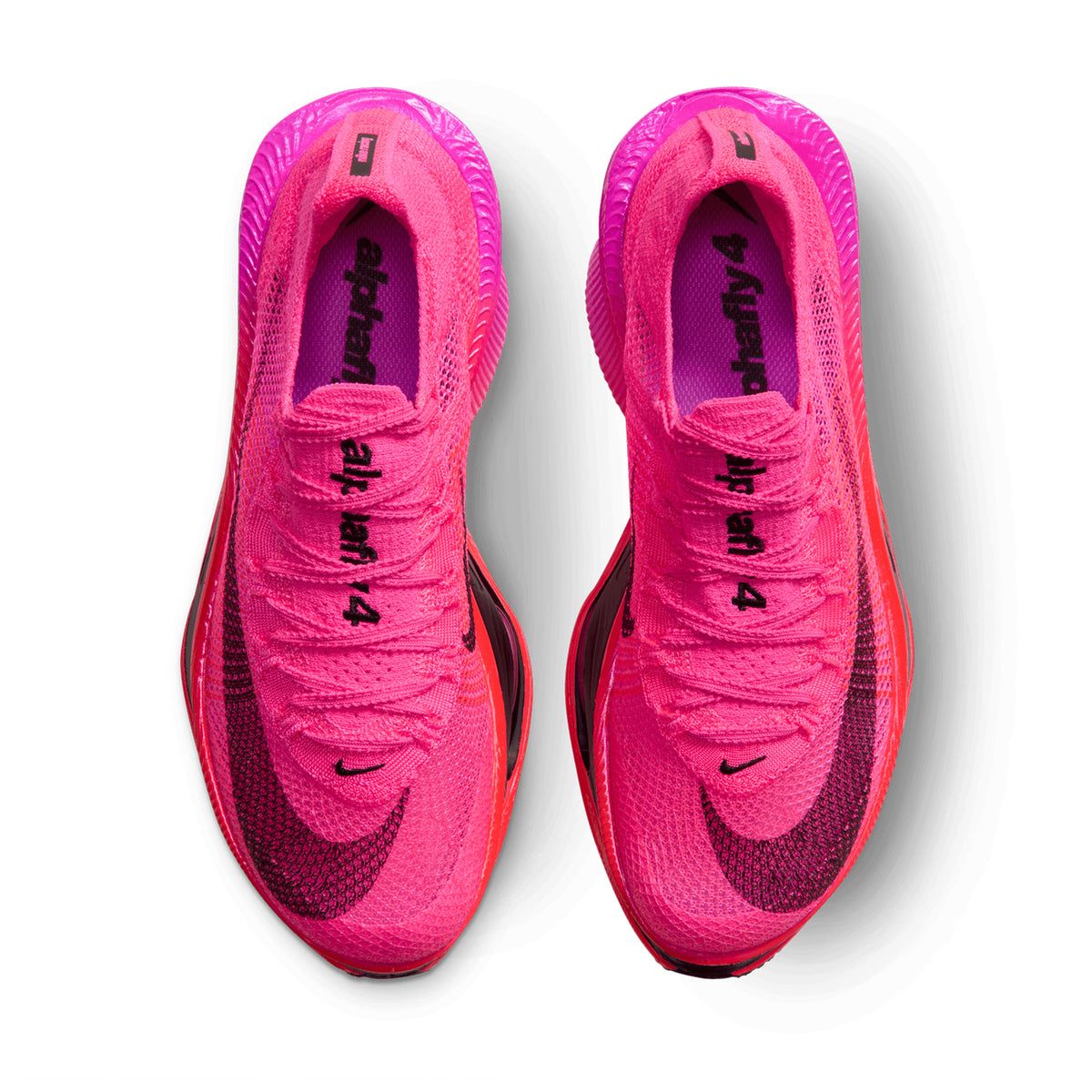 A pair of bright pink Women’s Alphafly 4 Running Shoes Hyper Pink / Black-Fuchsia Blast viewed from above, featuring black logos and text on the insoles.