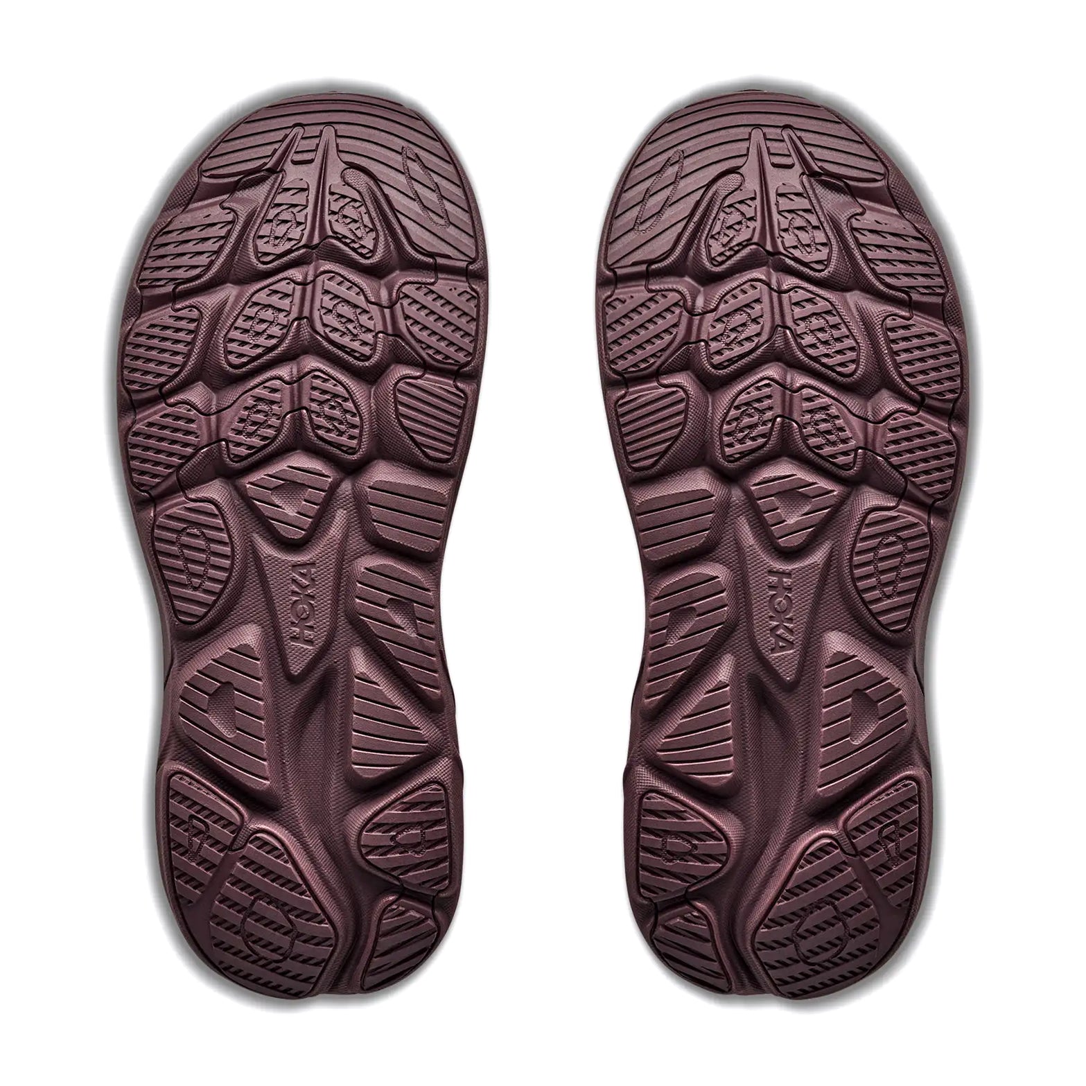Two brown outsoles from the Hoka Women’s Clifton 11 GORE-TEX Running Shoes in Smoky Quartz / Deep Mauve are displayed side by side on a white background. Featuring geometric tread patterns with a mix of curved and angular grooves, these waterproof running shoe soles are designed to enhance traction.