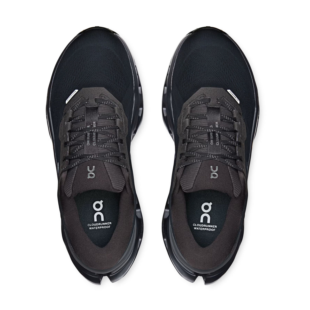Top view of a pair of Women’s Cloudrunner 3 Waterproof Running Shoes in Black / Black by On, featuring dark gray laces and the On logo visible on both the tongue and insole, designed to deliver enhanced stability with every run.