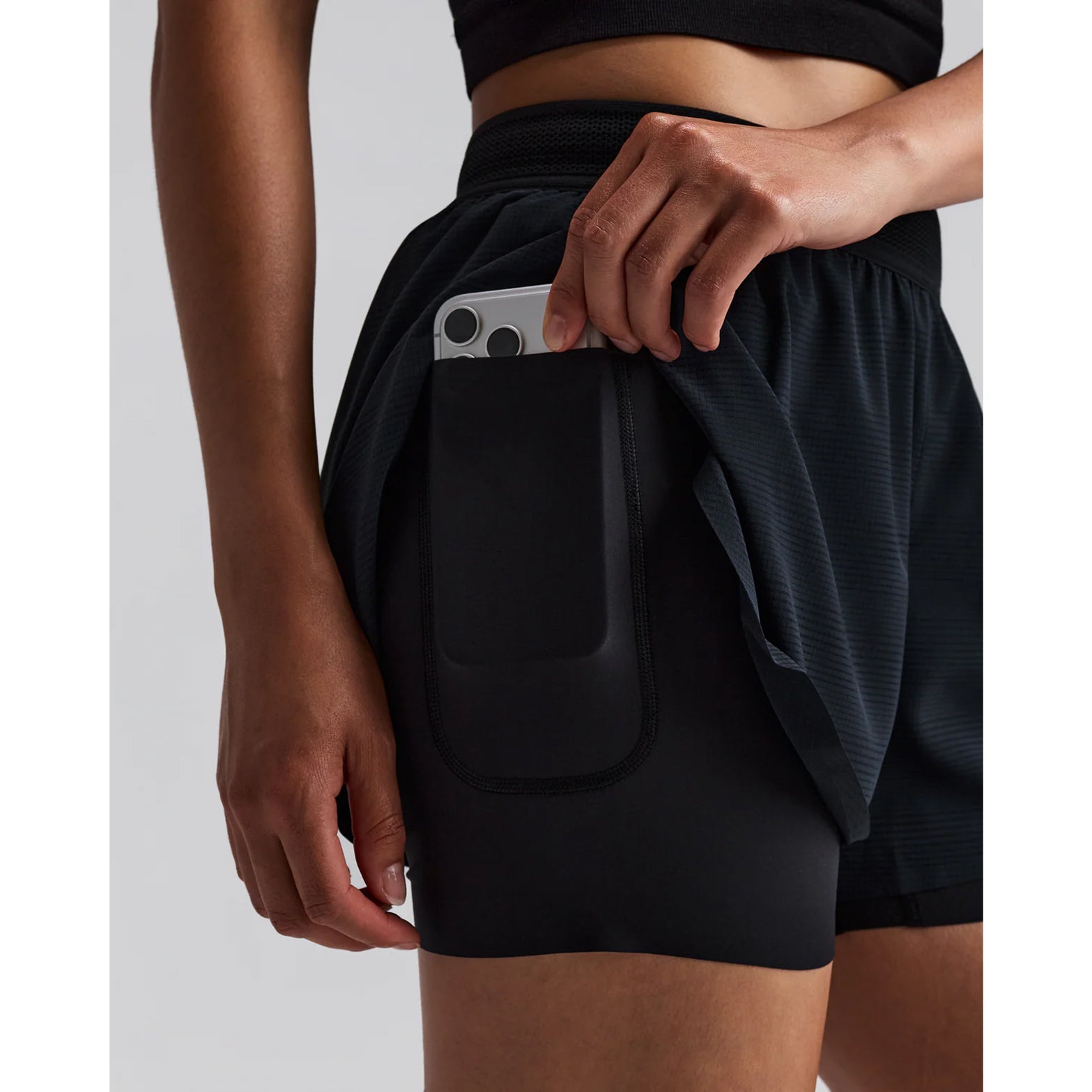 Women's Bandit CoolGrid 2-in-1 Run Short Black close-up of waterproof side leg phone pocket showing secure hidden storage with zero-bulk design for running essentials without bounce