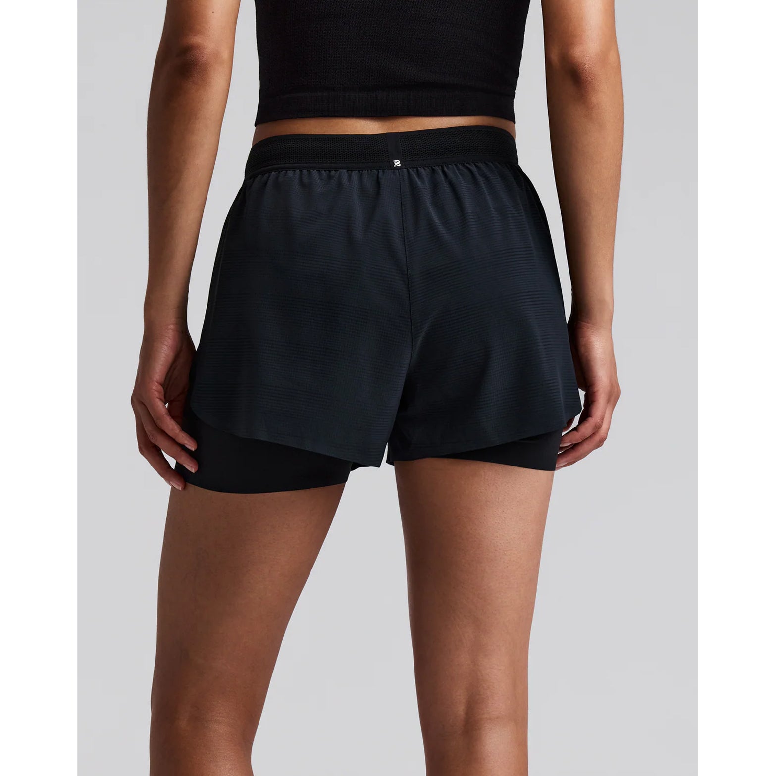Women's Bandit CoolGrid 2-in-1 Run Short Black back view on female runner showing reflective centre back branding with CoolGrid breathable construction and moisture-wicking liner