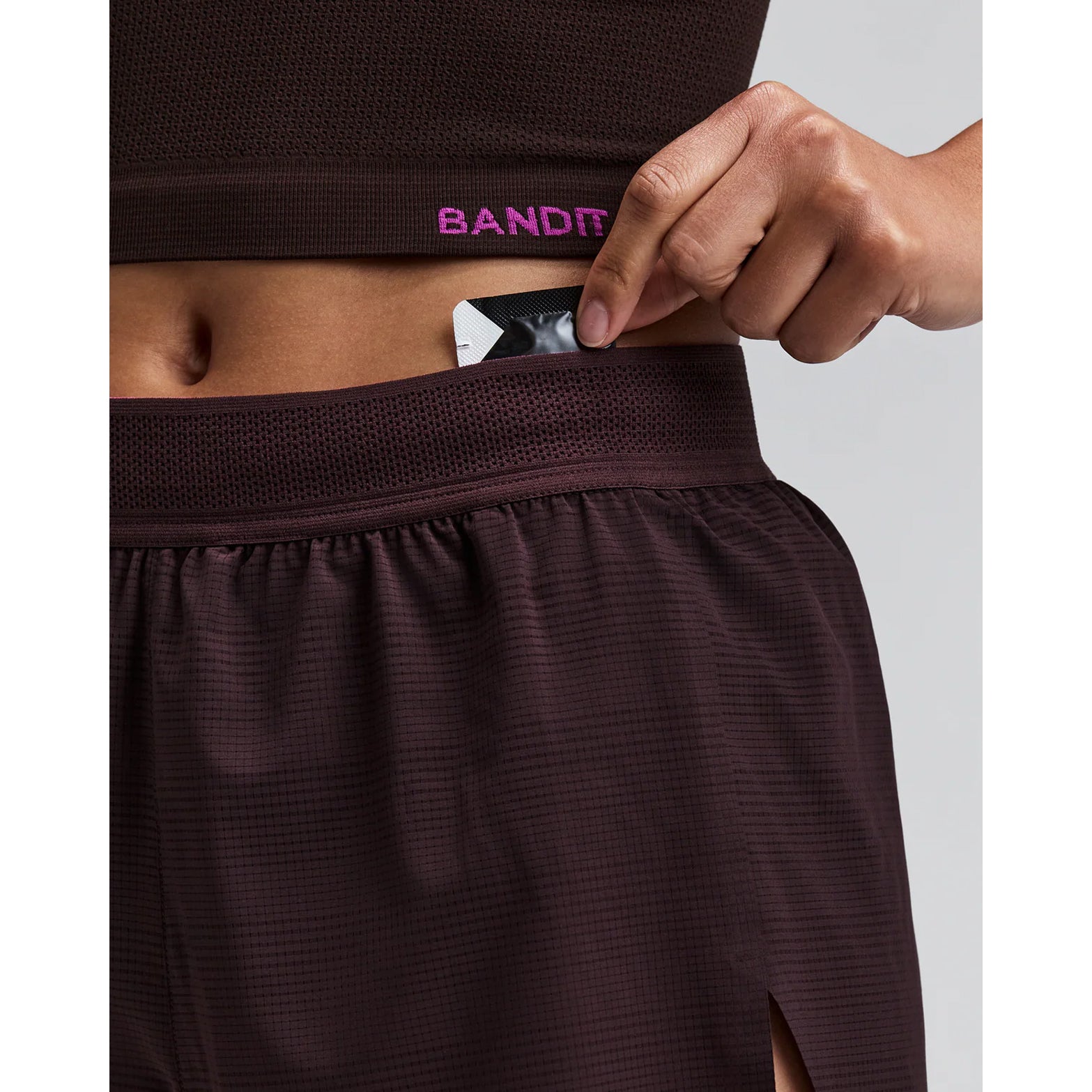 Women's Bandit CoolGrid 3 Inch Split Shorts Espresso close-up of pocket system showing waterproof phone pocket, four gel pockets and key fob pocket with zero-bulk design for running essentials