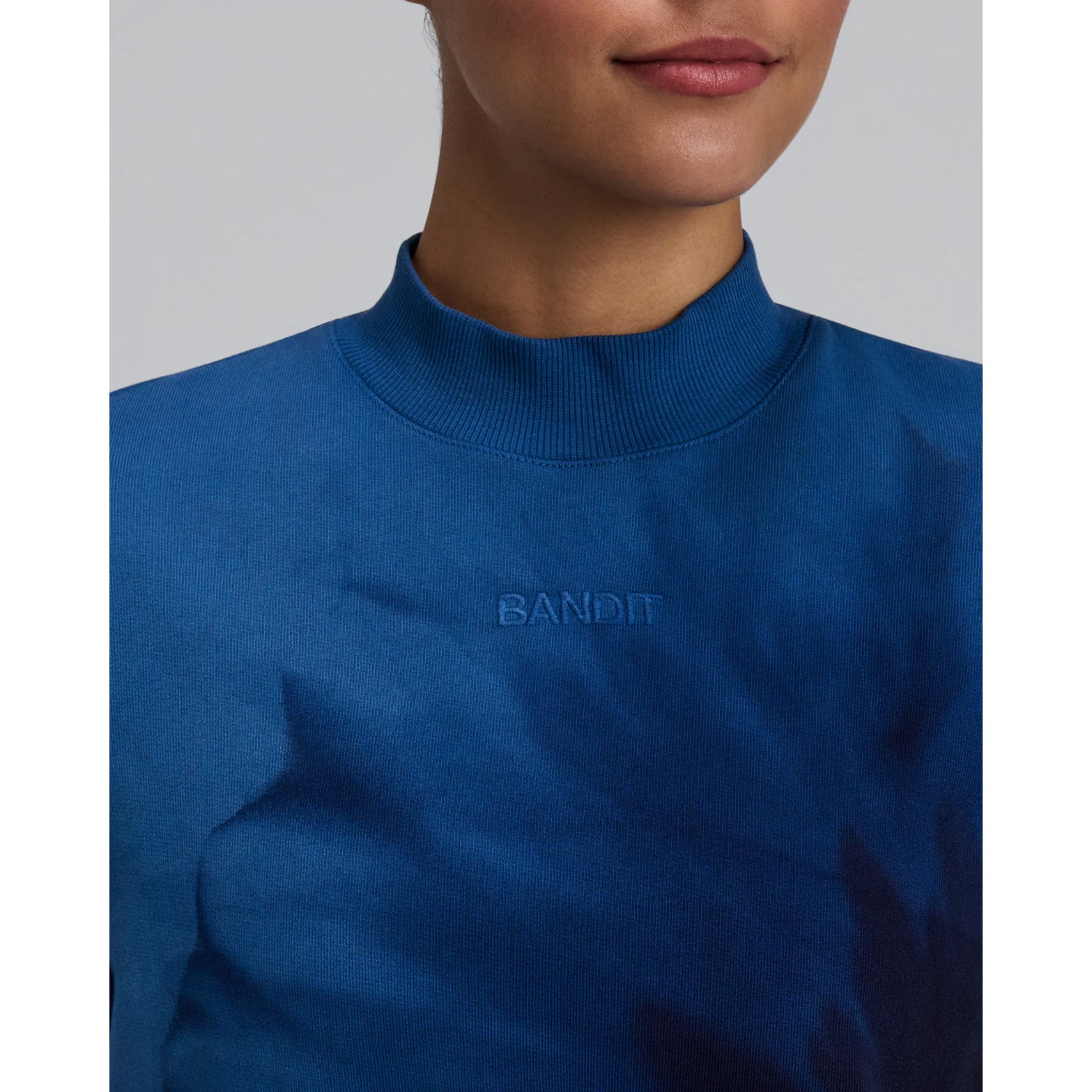 Bandit Cropmock Pullover women's in Aegean Blue Wave Print — closeup showing embroidered Bandit branding on aegean blue wave print cotton fleece fabric