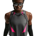 A person wearing a Nike Women’s Dri-FIT ADV Cropped Running Vest in Iron Grey, Volt, and White stands against a white background, facing forward.