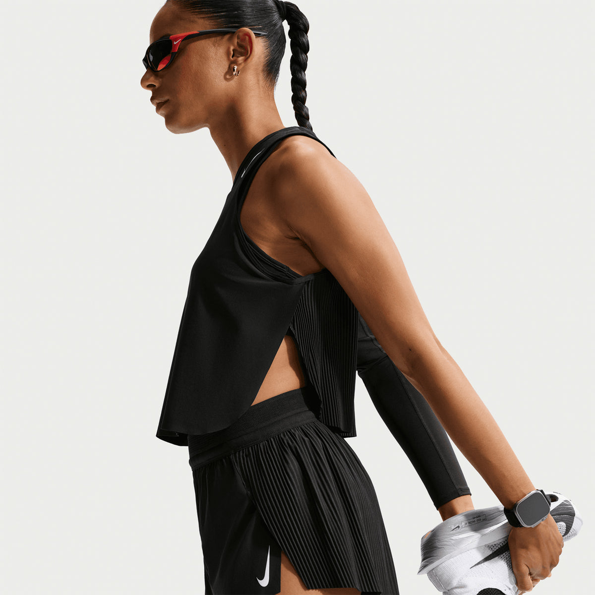 Women's Nike Dri-FIT Aeroswift ADV Cropped Running Tank Black White side view on female runner showing cropped construction with Dri-FIT ADV moisture-wicking and breathable fabric for racing and tempo runs