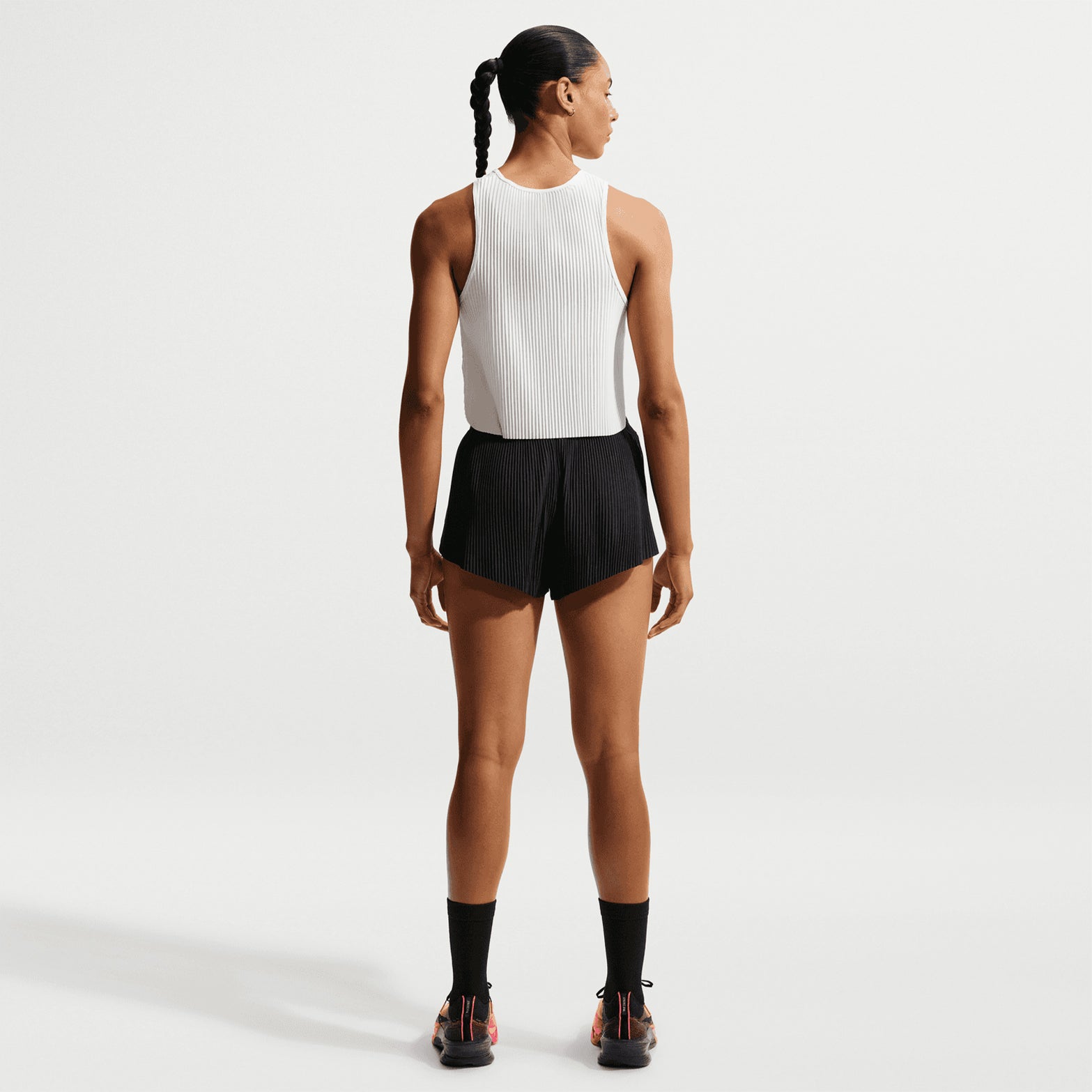 Women's Nike Dri-FIT AeroSwift ADV Mid-Rise 3 Inch Running Shorts Black White full body back view on female runner showing split sides for freedom of movement and reflective details