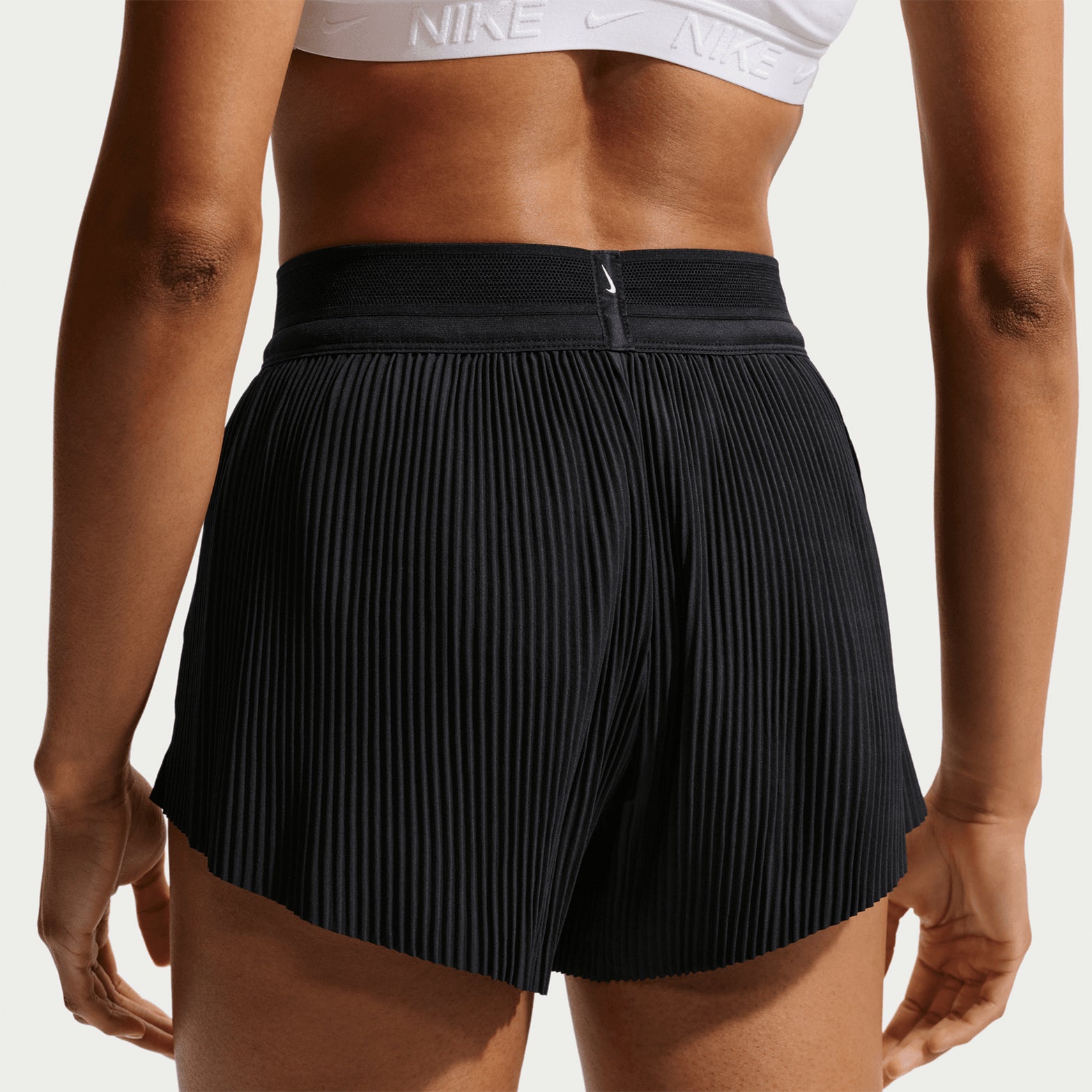 Women's Nike Dri-FIT AeroSwift ADV Mid-Rise 3 Inch Running Shorts Black White close-up back view showing pleated detail, reflective elements and split hem construction