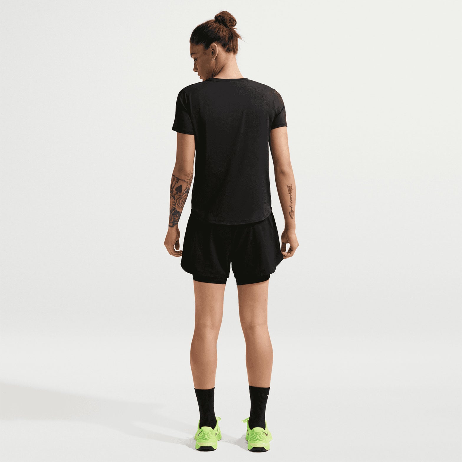 Women's Nike Dri-FIT High-Waisted 3 Inch 2-in-1 Shorts Black White full body back view on female model showing chafe-preventing inner layer and high-rise fit