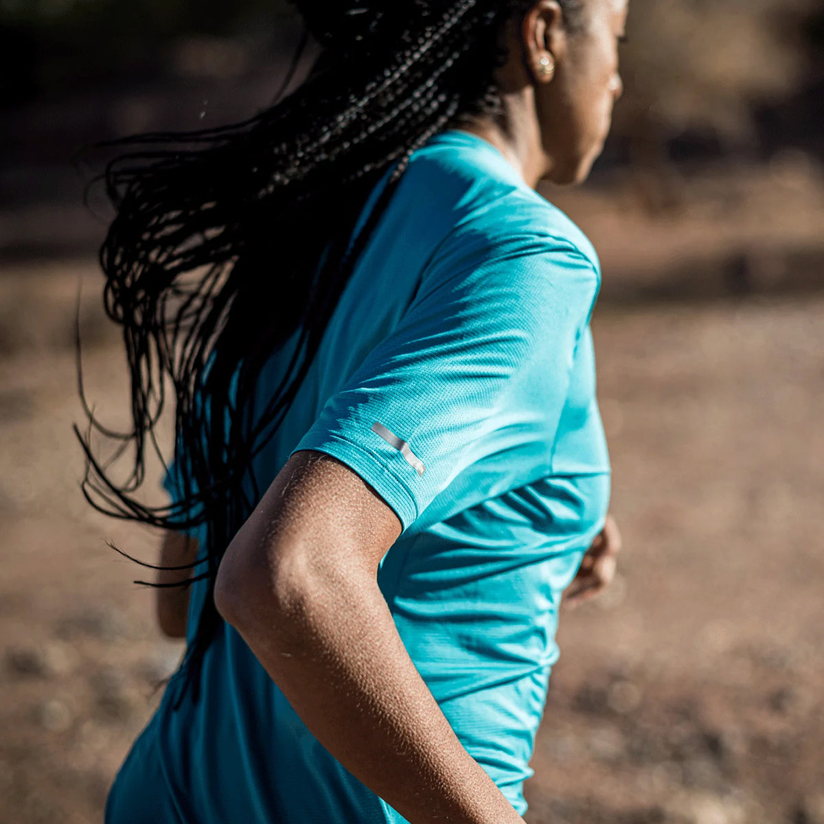 Women's Soar Eco Tech Tee close-up side view on model showing recycled Italian mesh fabric texture and reflective detail