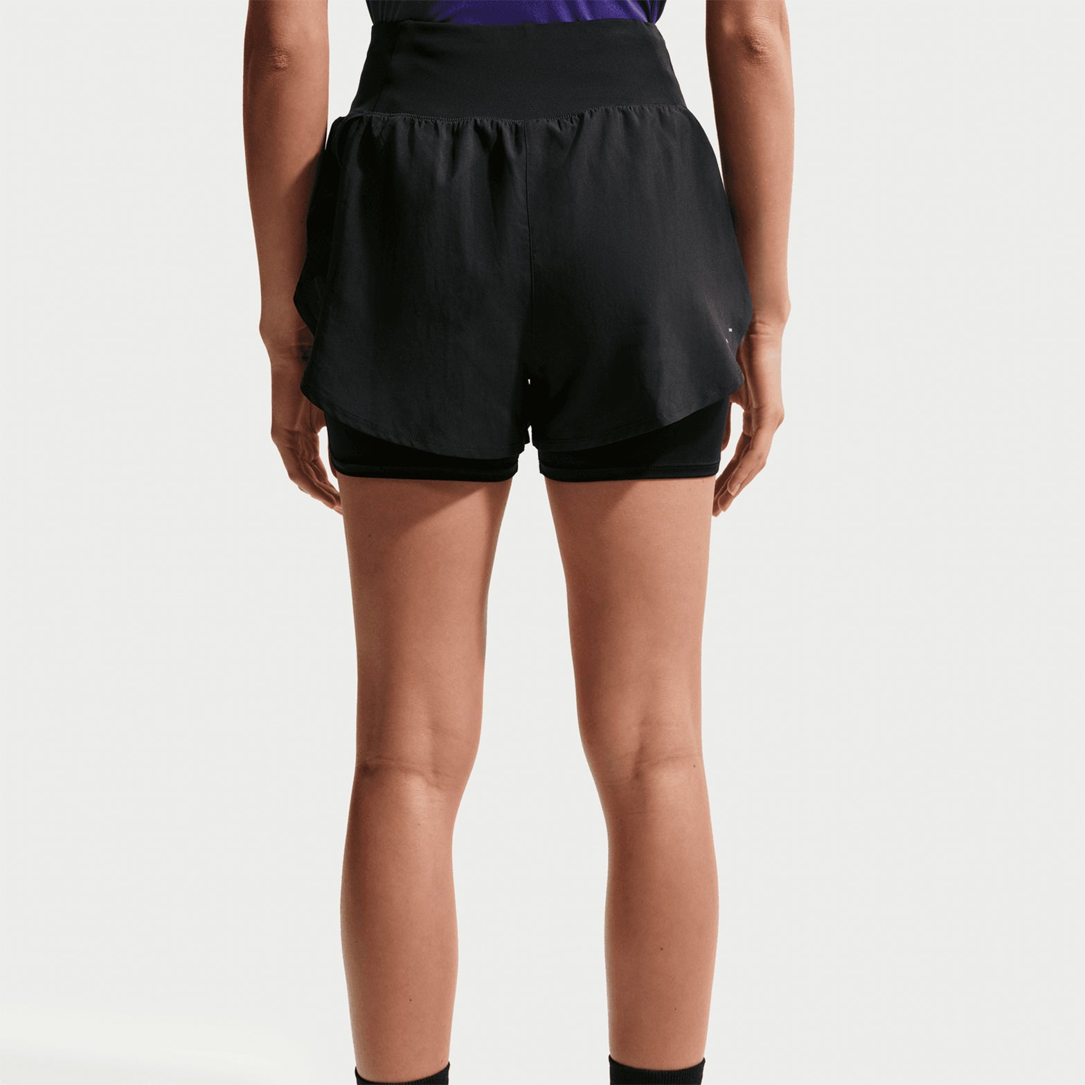 Women's Nike Flow Dri-FIT High-Waisted 2 in 1 Shorts Black back view on female runner showing back waistband phone pocket with Dri-FIT moisture-wicking construction and reflective details