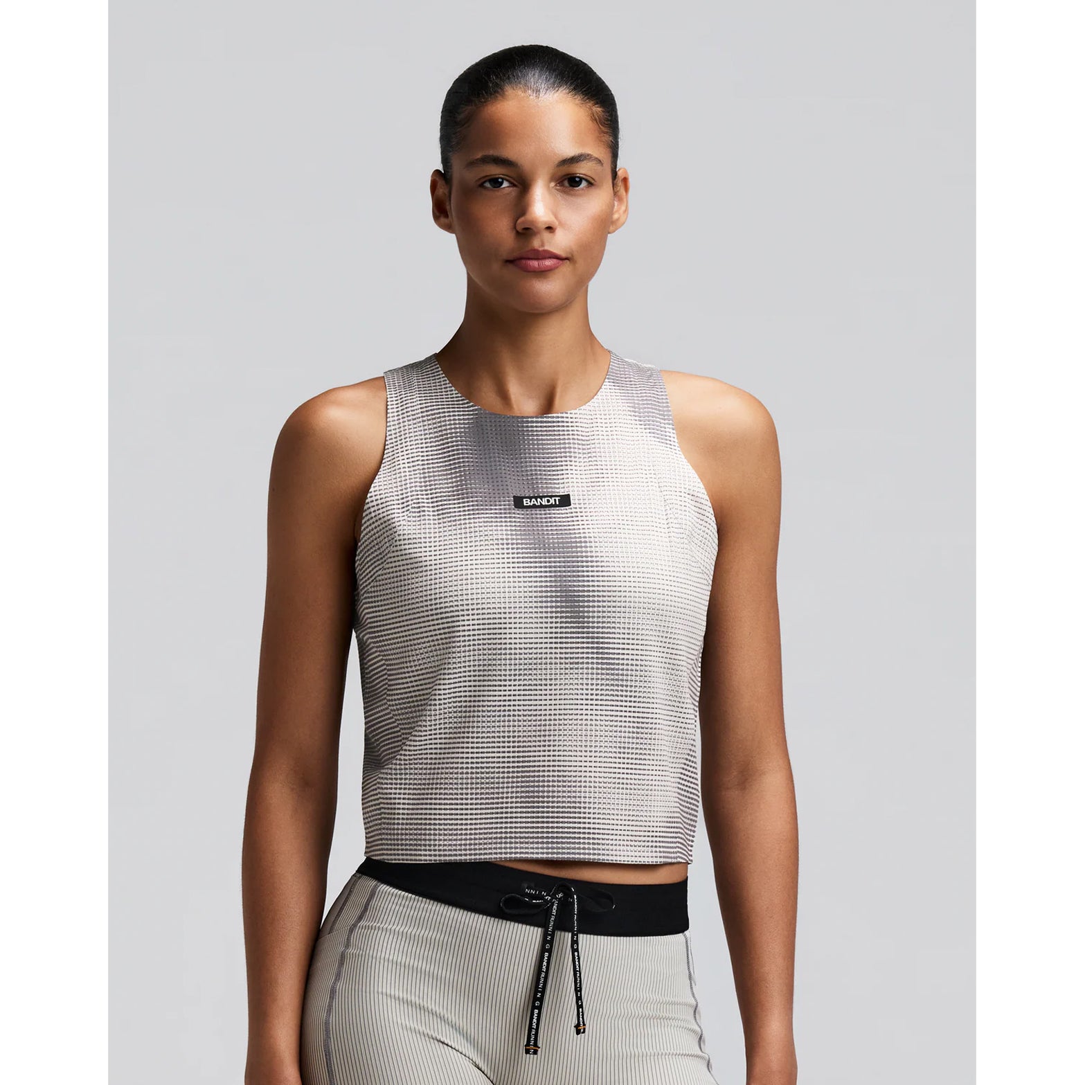 Women's Bandit GeoMesh Race Singlet Slate Plaster front view on female runner showing GeoMesh breathable performance knit with cropped design and bonded finishing for race day performance
