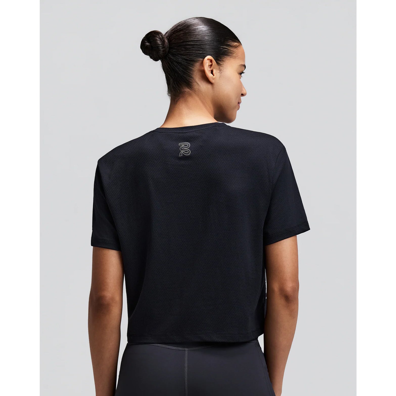 Women's Bandit Micromesh Cropped Run Tee Black back view on female runner showing breathable Micromesh construction with fast-drying sweat-wicking fabric for comfortable running