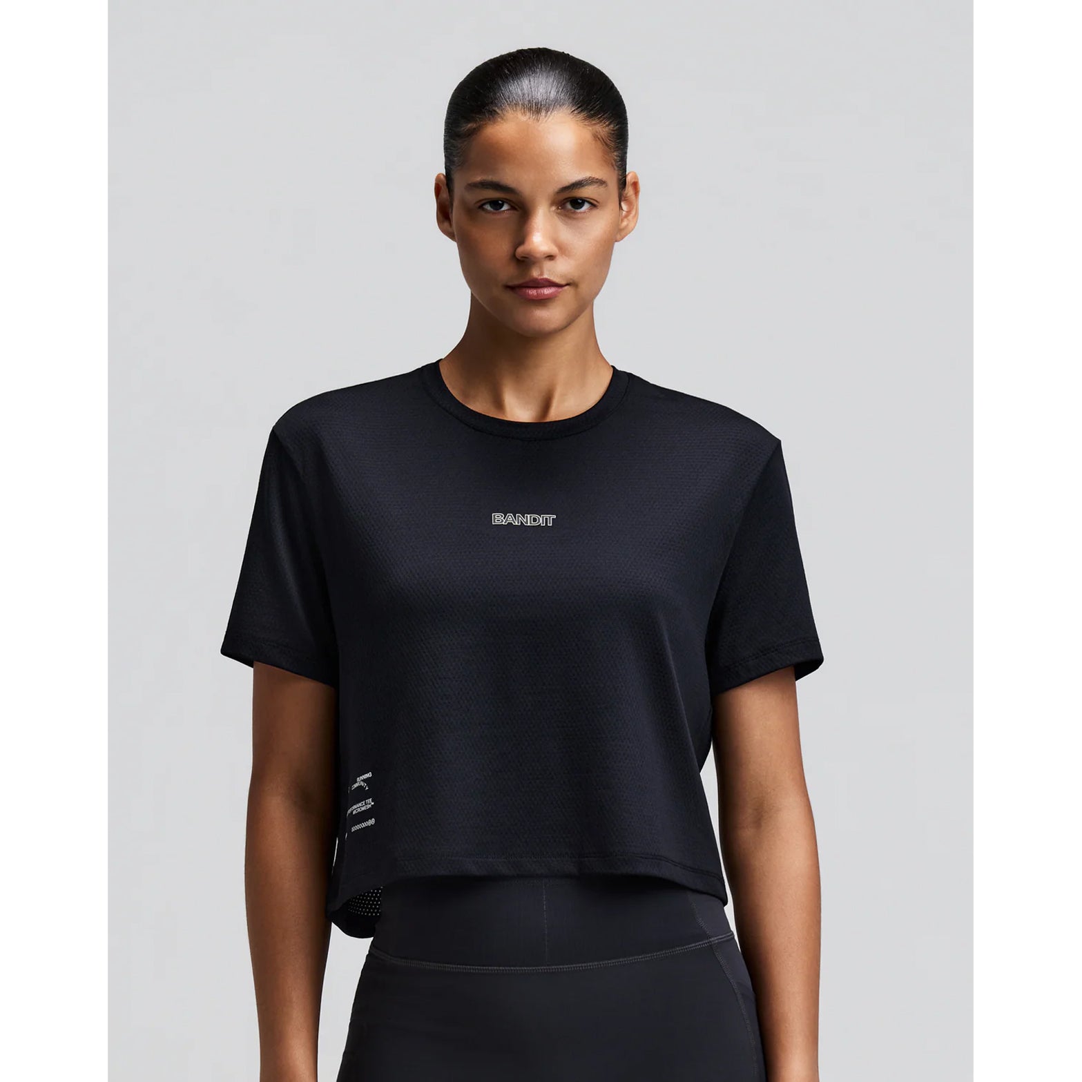Women's Bandit Micromesh Cropped Run Tee Black front view on female runner showing boxy cropped fit with crew neckline and breathable Micromesh construction for running and training