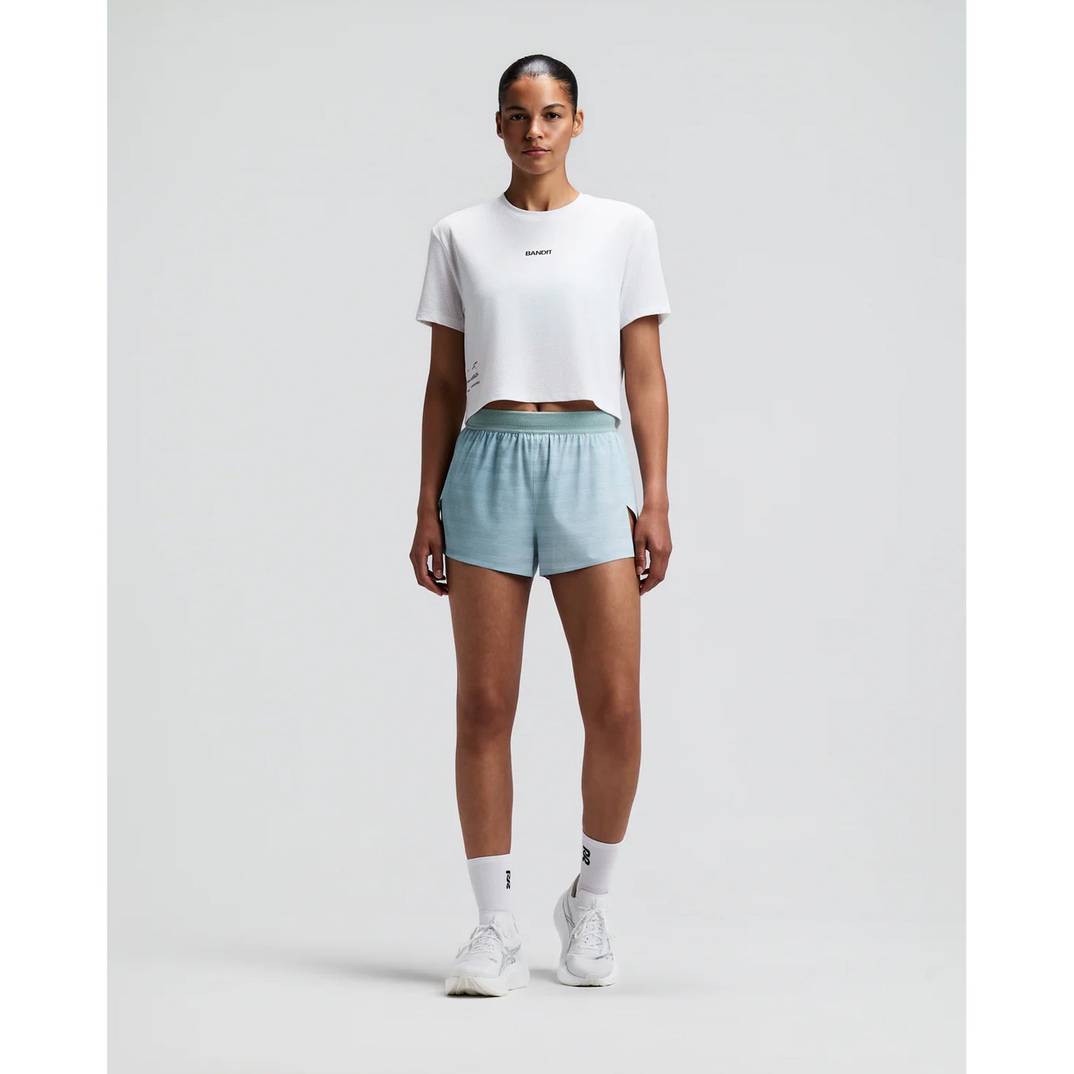 Women's Bandit Micromesh Cropped Run Tee White front full body view on female runner showing relaxed boxy cropped silhouette with crew neckline and breathable Micromesh moisture-wicking for training and everyday running