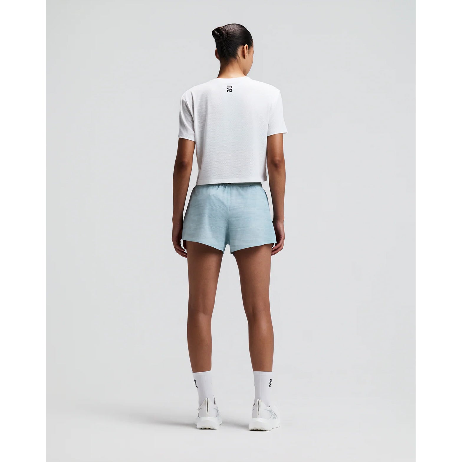 Women's Bandit Micromesh Cropped Run Tee White back full body view on female runner showing relaxed boxy cropped fit with fast-drying Micromesh construction for comfortable running and training