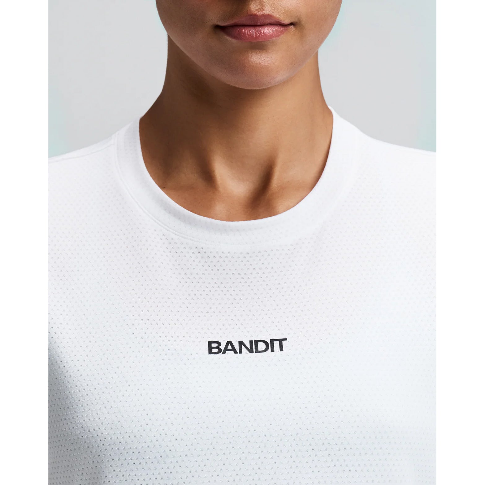 Women's Bandit Micromesh Cropped Run Tee White close-up of front showing subtle two-tone Bandit logo branding with ultra-breathable Micromesh fabric and Oeko-Tex certified BPA-free construction