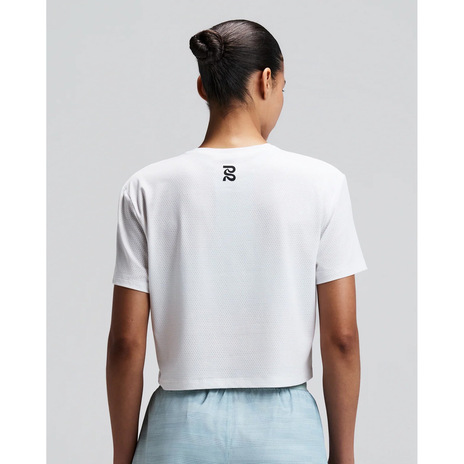 Women's Bandit Micromesh Cropped Run Tee White back view on female runner showing breathable Micromesh construction with fast-drying sweat-wicking fabric for comfortable running