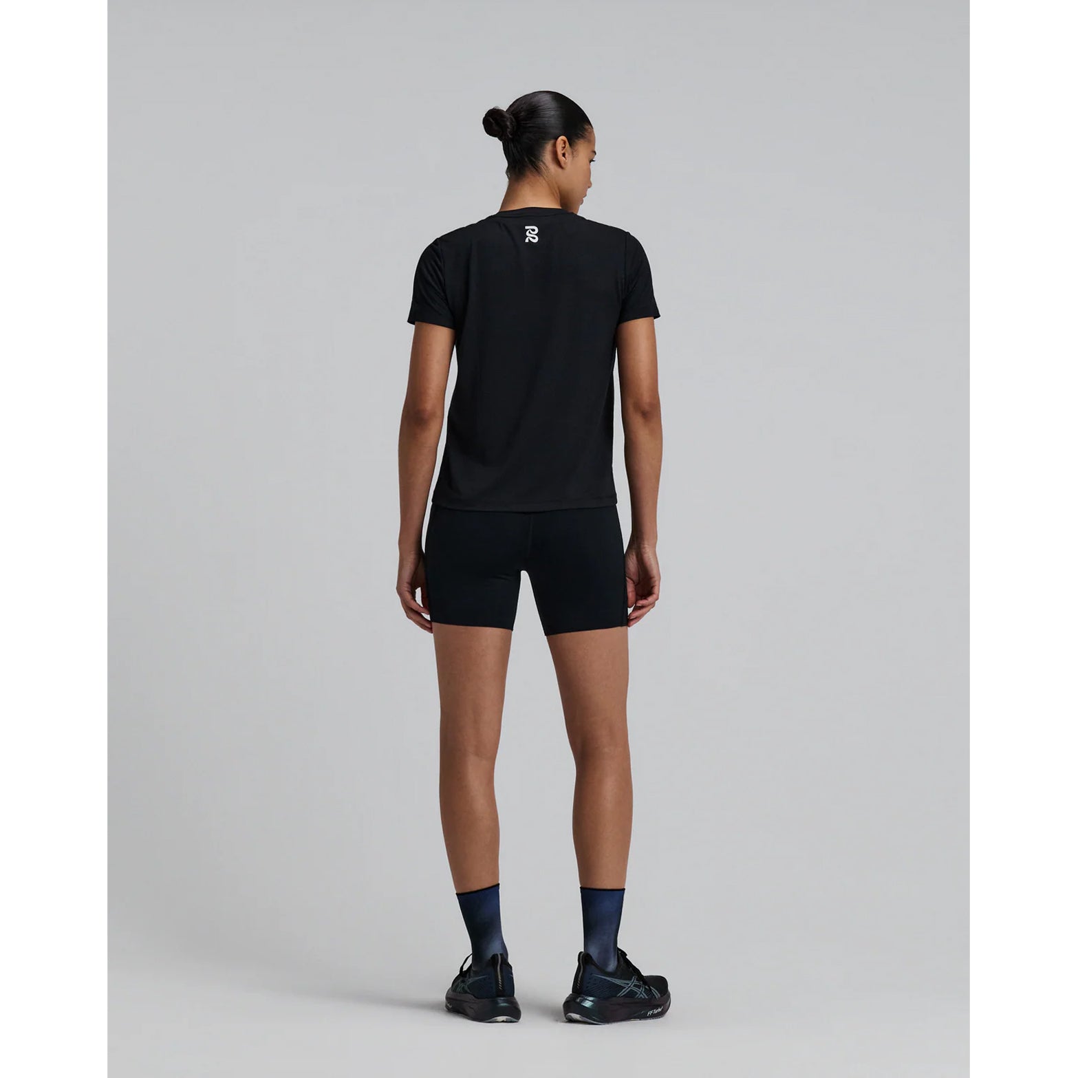 Bandit Micromesh Run Tee women's in Black — full body back view worn on model showing relaxed fit silhouette, Micromesh™ breathable fabric construction and dyed-to-match reflective graphic at centre back

