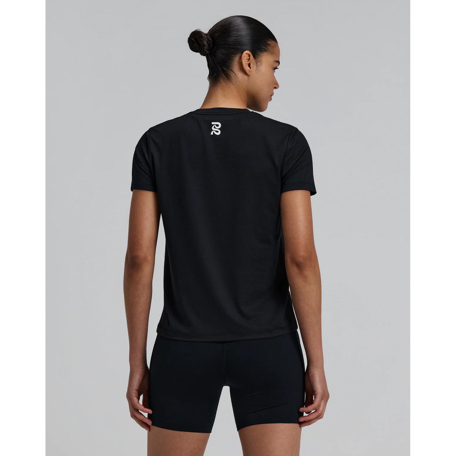 Bandit Micromesh Run Tee women's in Black — back view worn on model showing relaxed fit, Micromesh™ breathable fabric construction and dyed-to-match reflective graphic at centre back