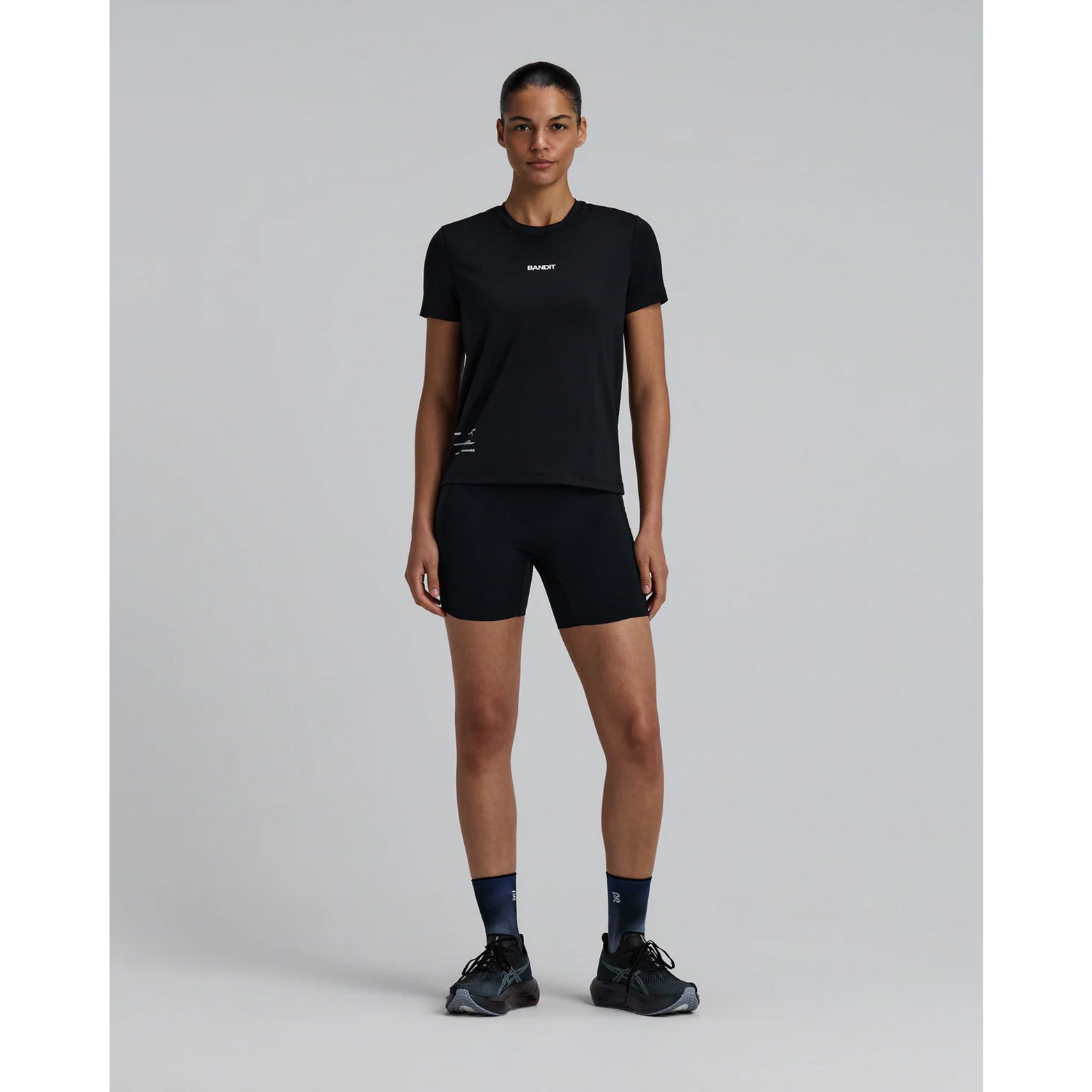 Bandit Micromesh Run Tee women's in Black — full body front view worn on model showing relaxed fit silhouette, Micromesh™ fabric drape and dyed-to-match reflective graphic at centre front