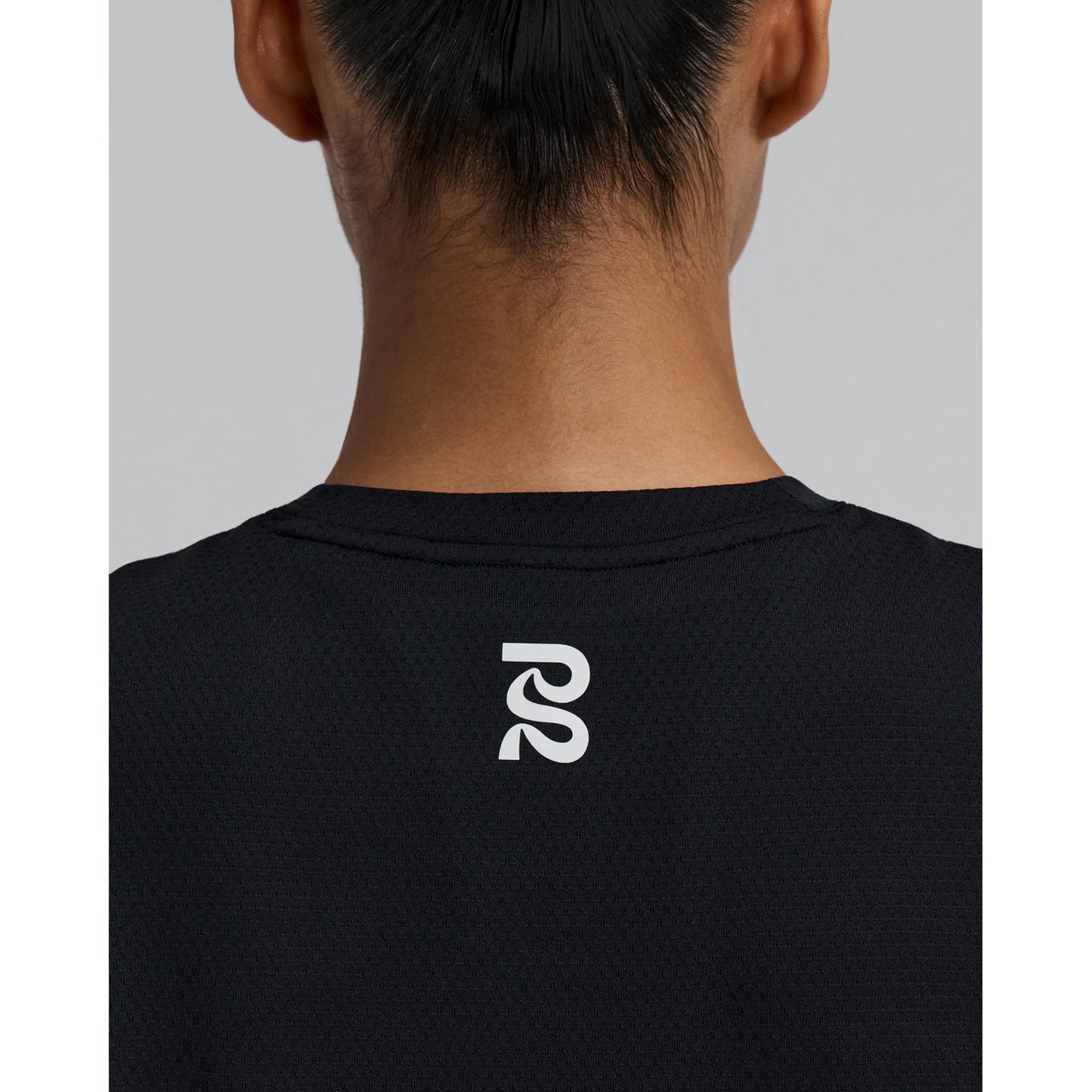 Bandit Micromesh Run Tee women's in Black — closeup showing dyed-to-match reflective graphic detail at centre back on Micromesh™ breathable fabric