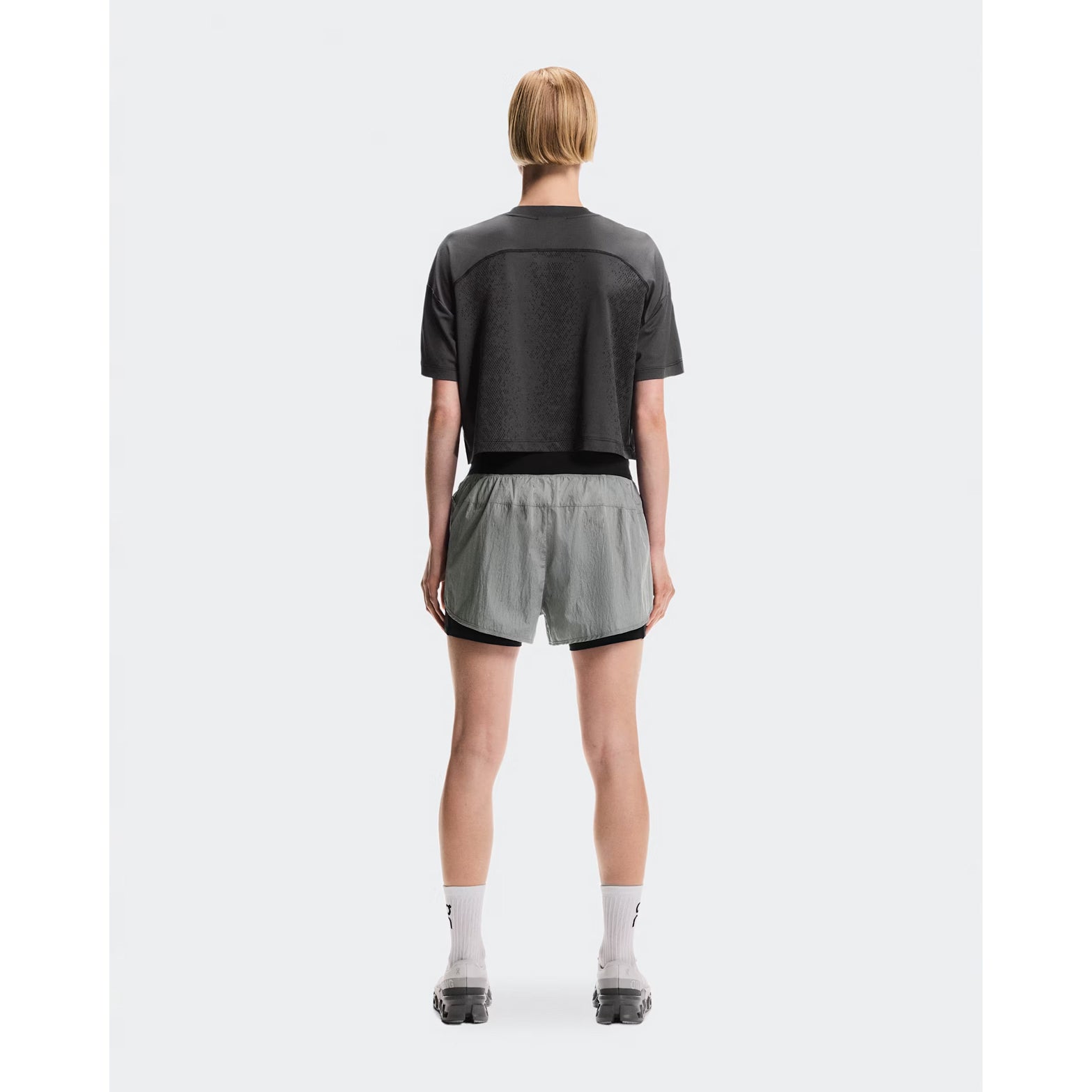 Women's On Performance Volt-T Iron full body back view on female runner showing versatile relaxed cut with quick-dry moisture-wicking performance for everyday activities