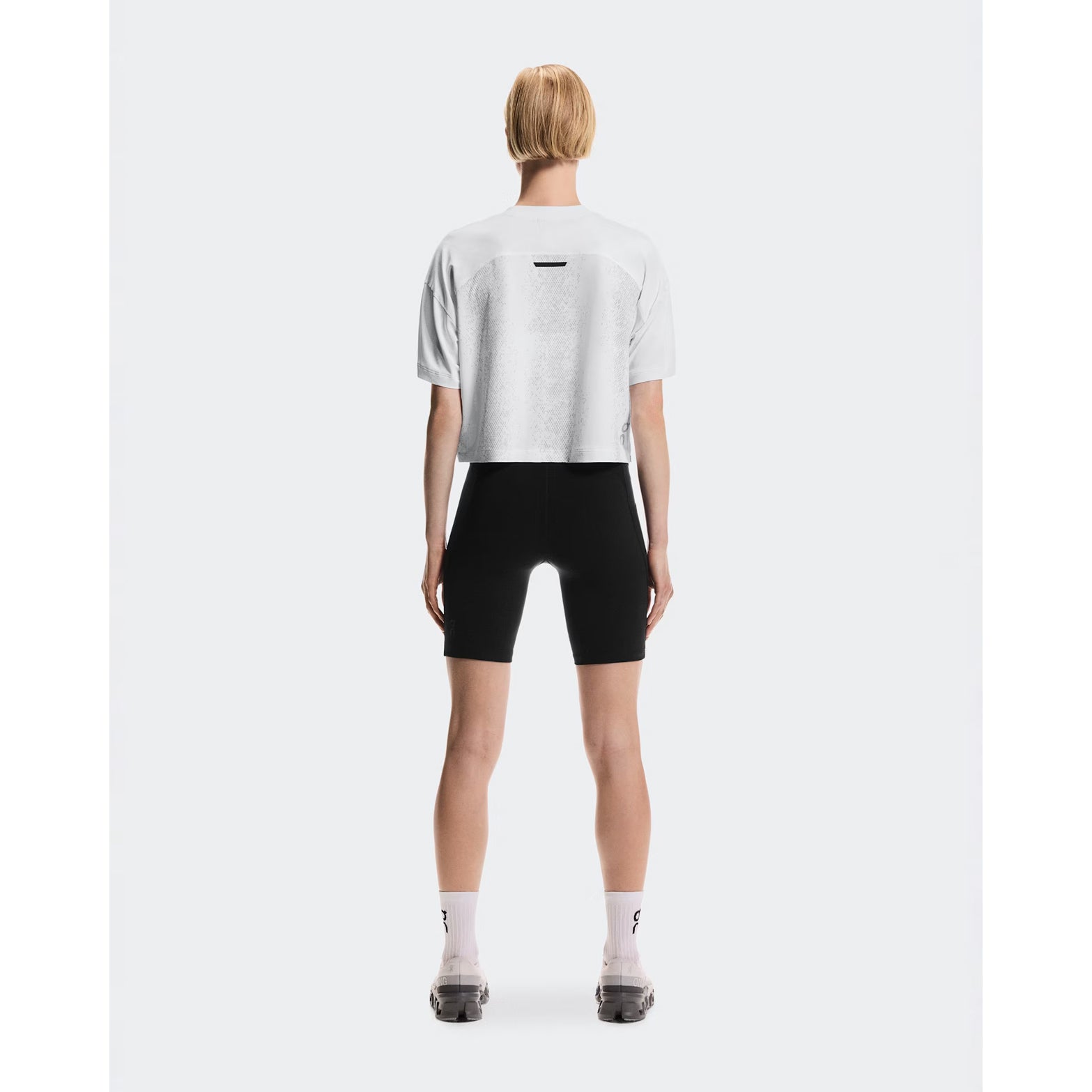 Women's On Performance Volt-T White full body back view on female runner showing versatile relaxed cut with quick-dry moisture-wicking performance for everyday activities
